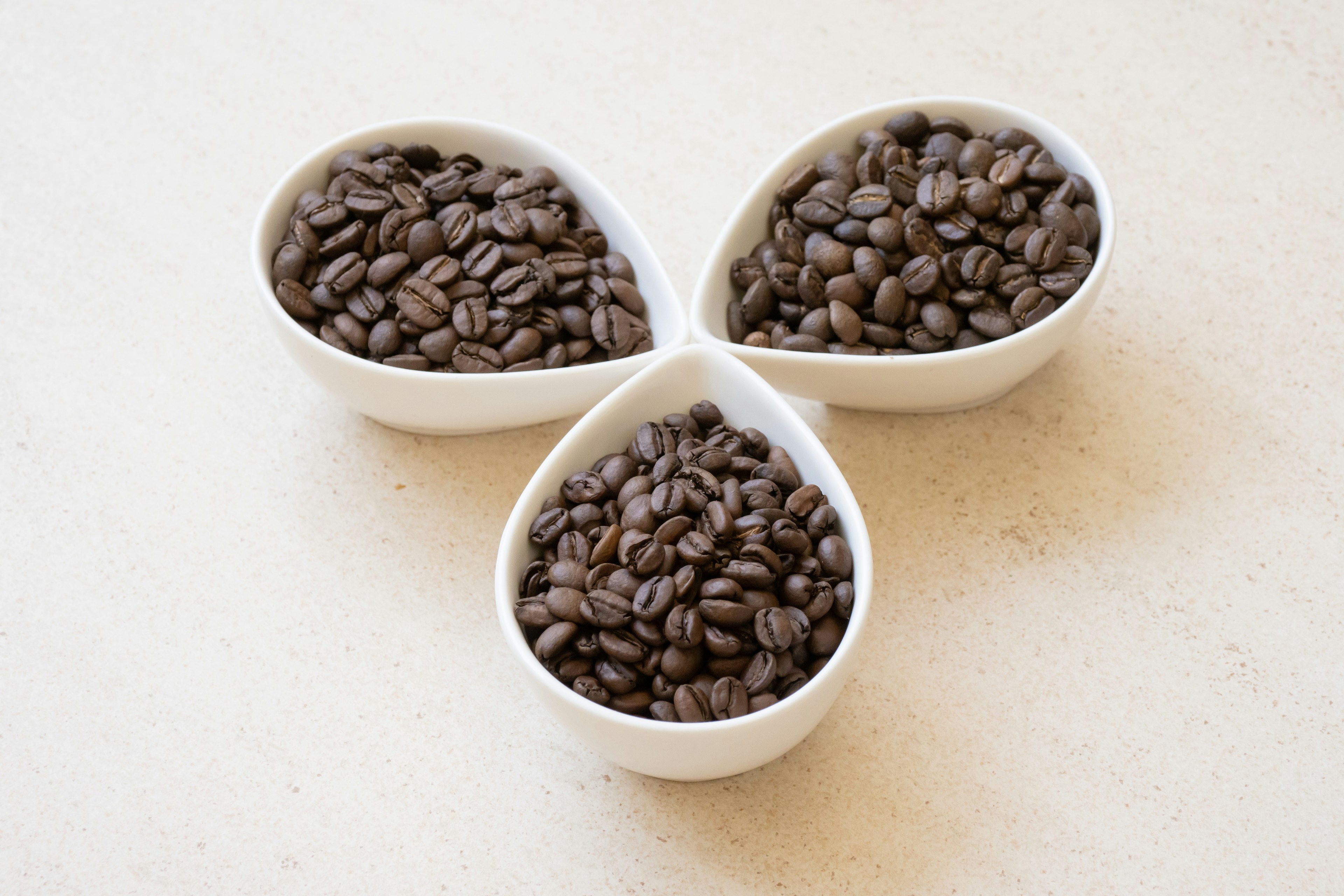 Image of coffee beans in three white bowls