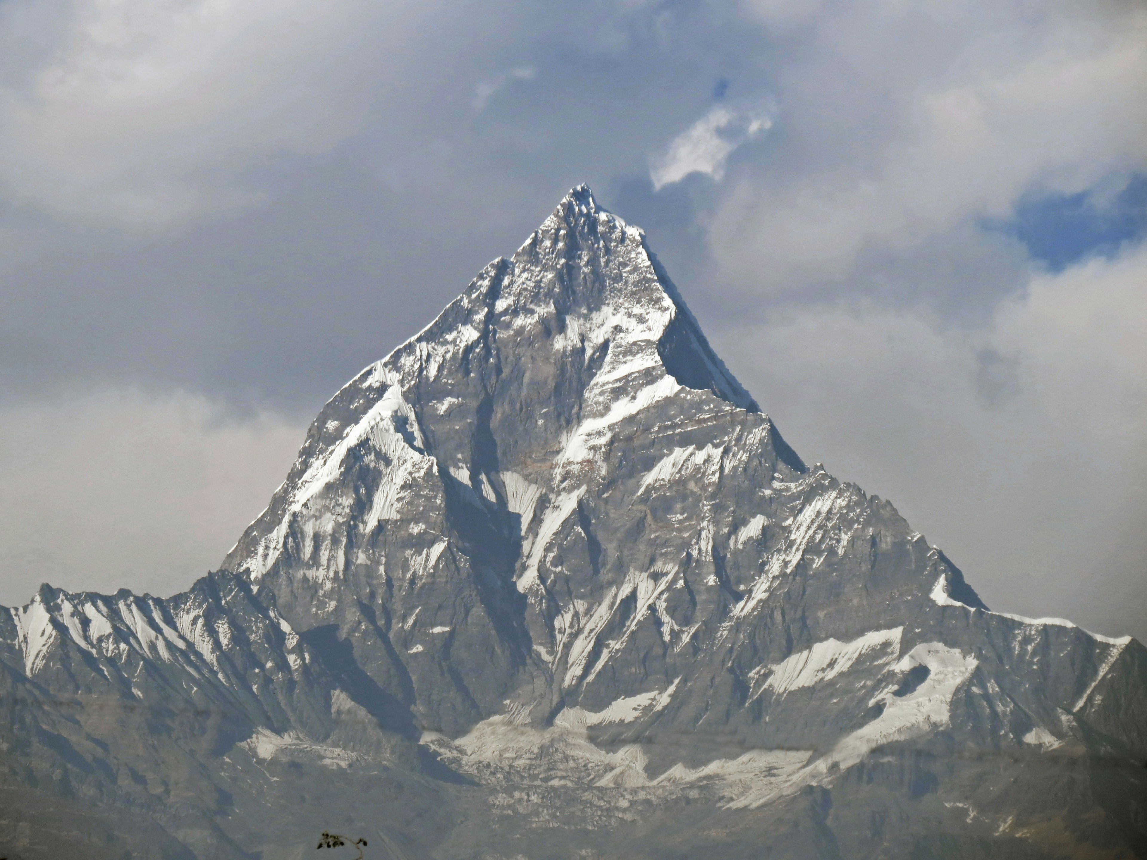 Schneebedeckter Berggipfel mit dramatischen Wolken