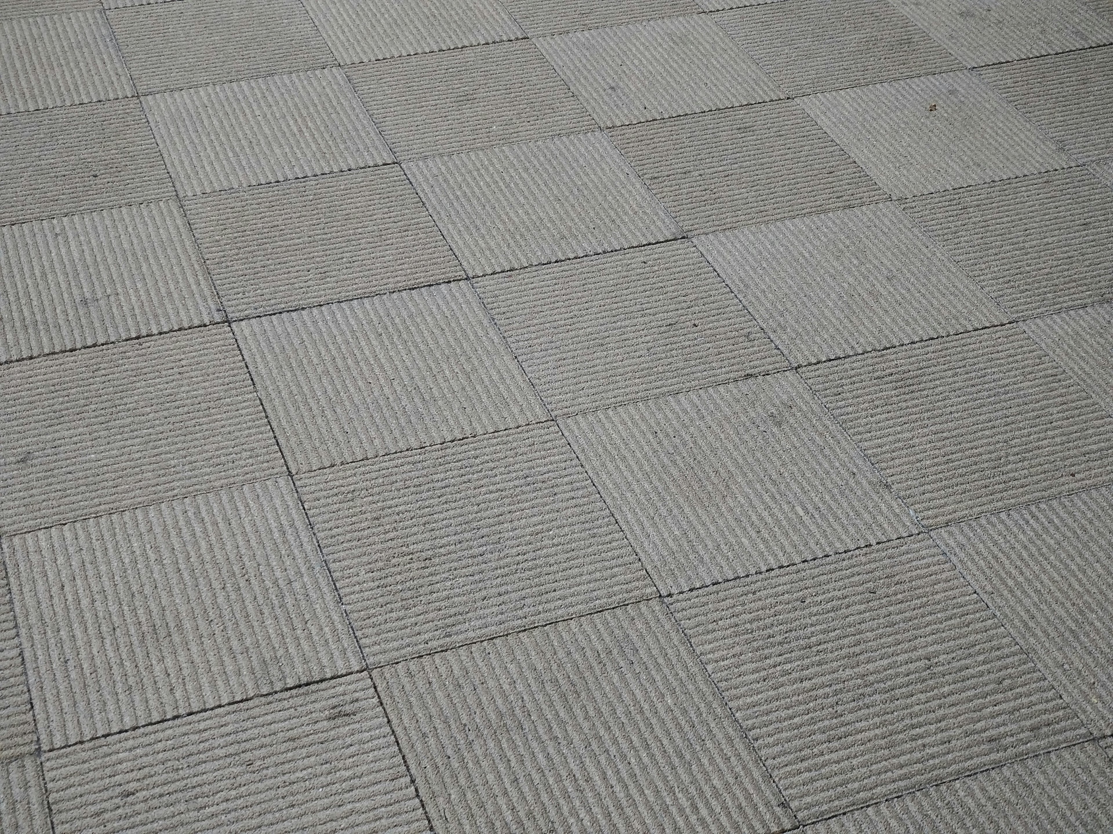 Sol en carreaux gris avec des motifs texturés alternés