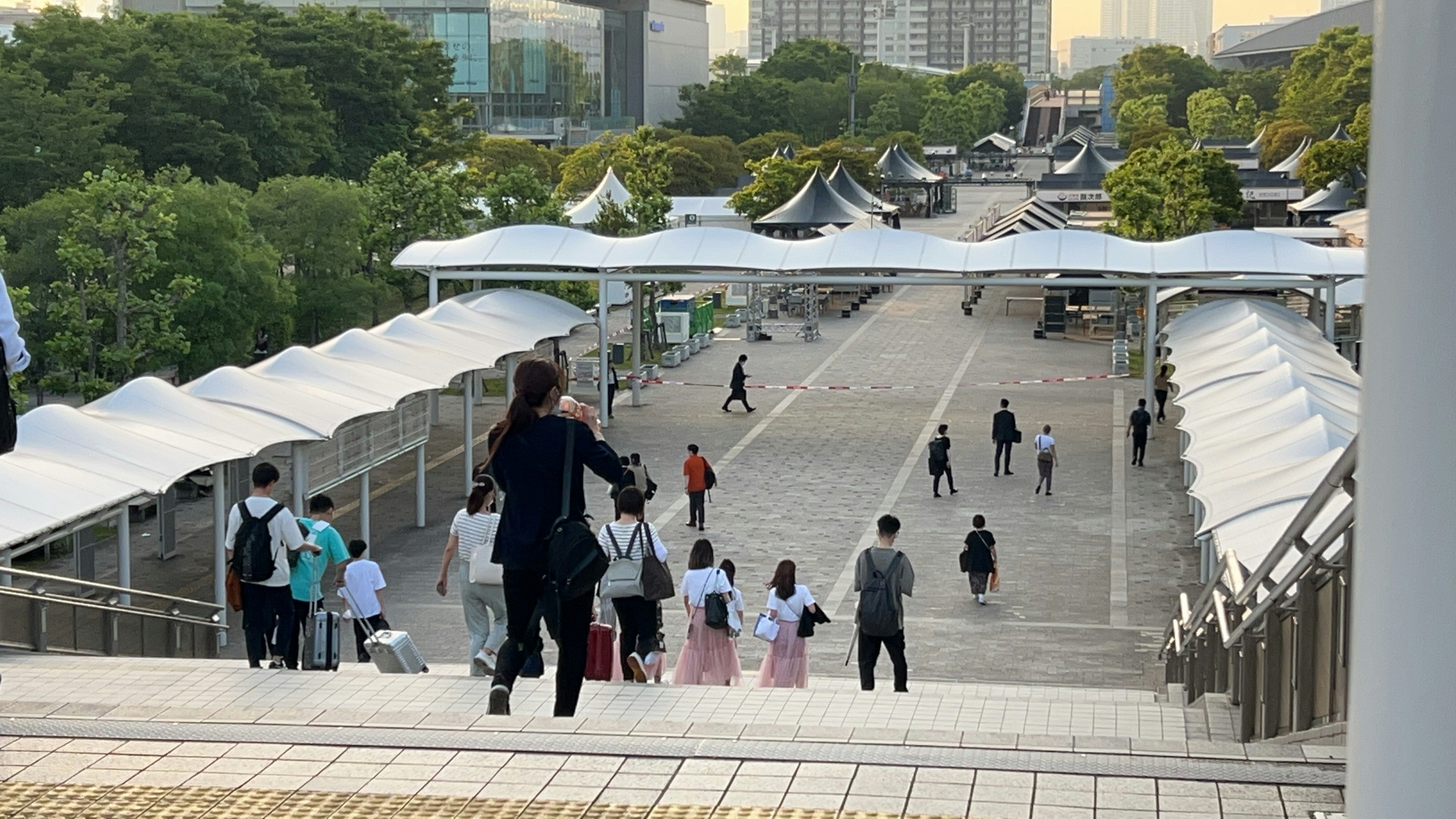 広場で人々が歩く様子と屋根付きの通路