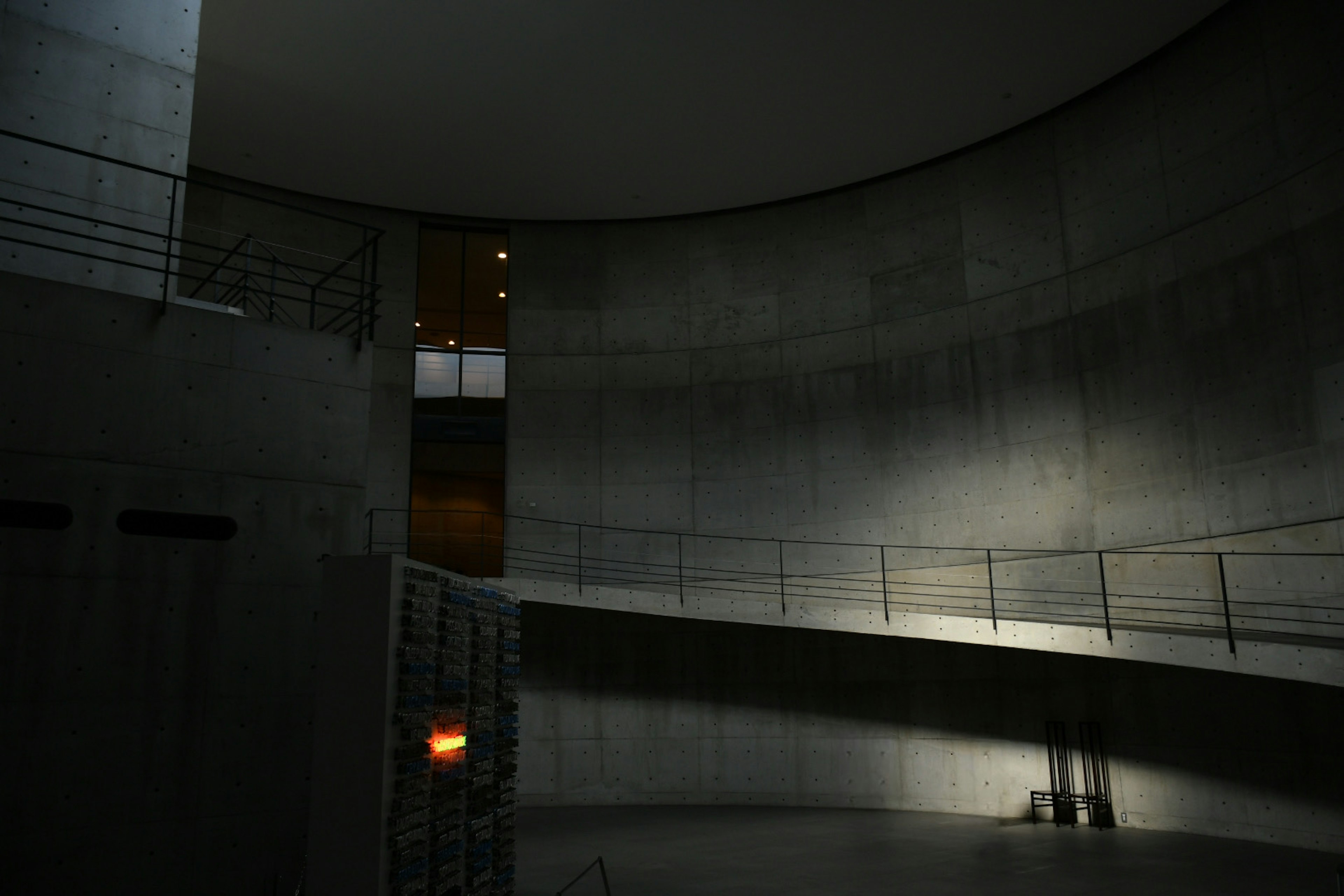 Interior of a modern space with curved concrete walls and ambient lighting