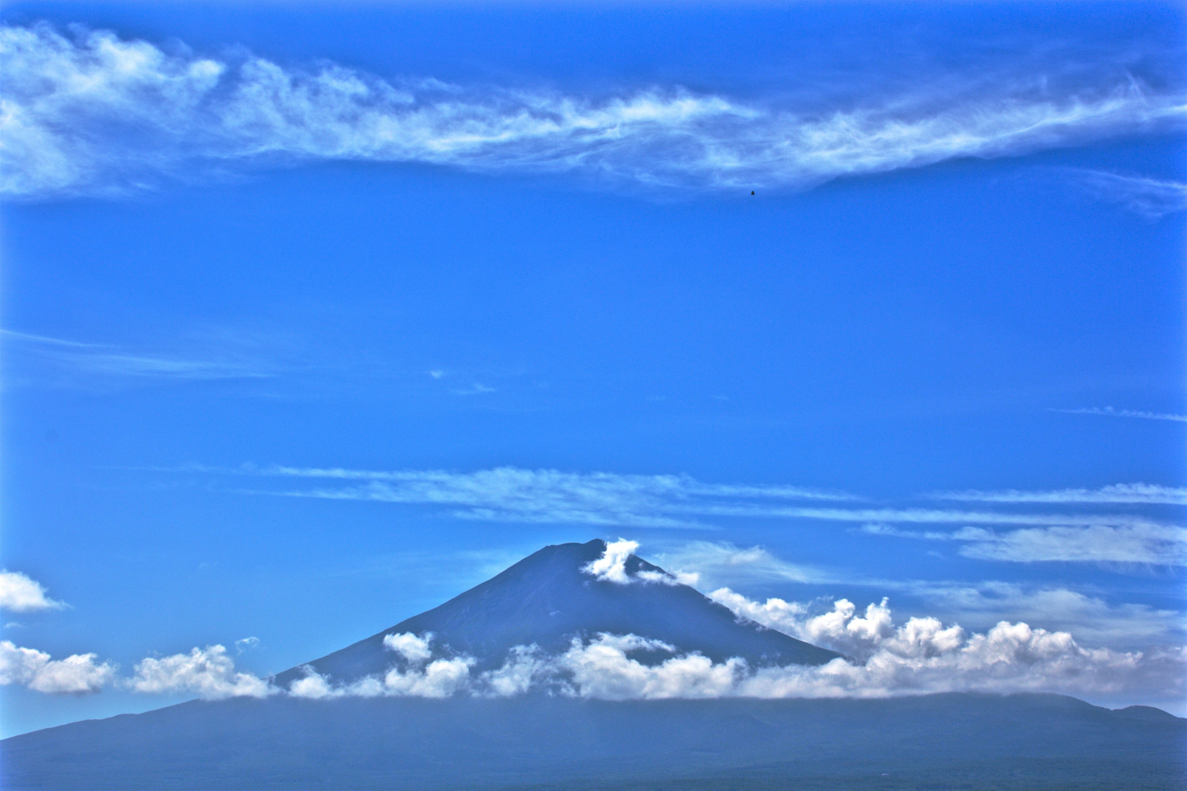 青空の下にそびえる山と雲の景色