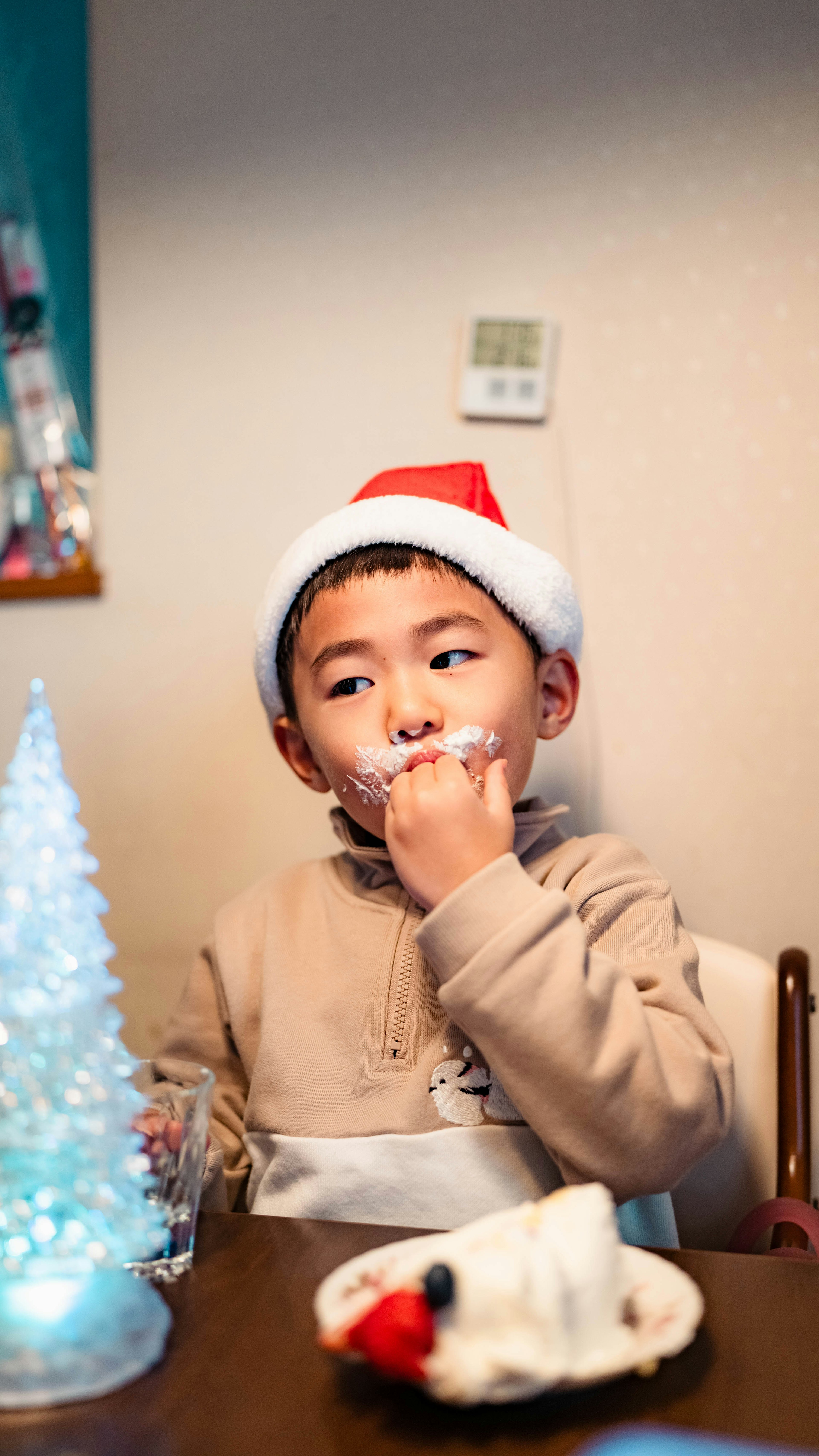 クリスマスハットをかぶった少年がケーキを食べているシーン