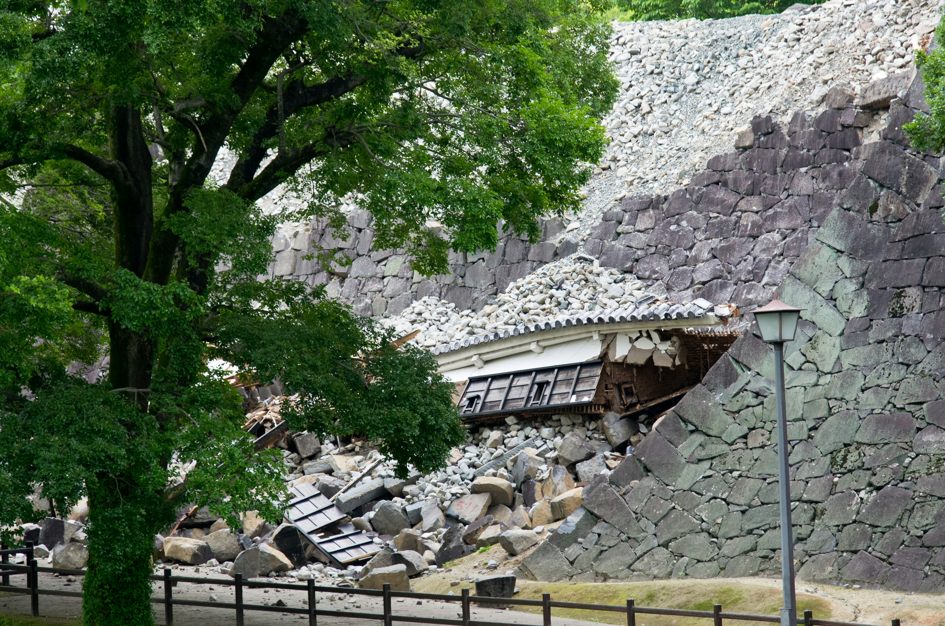 Ladera colapsada con un edificio dañado y árboles