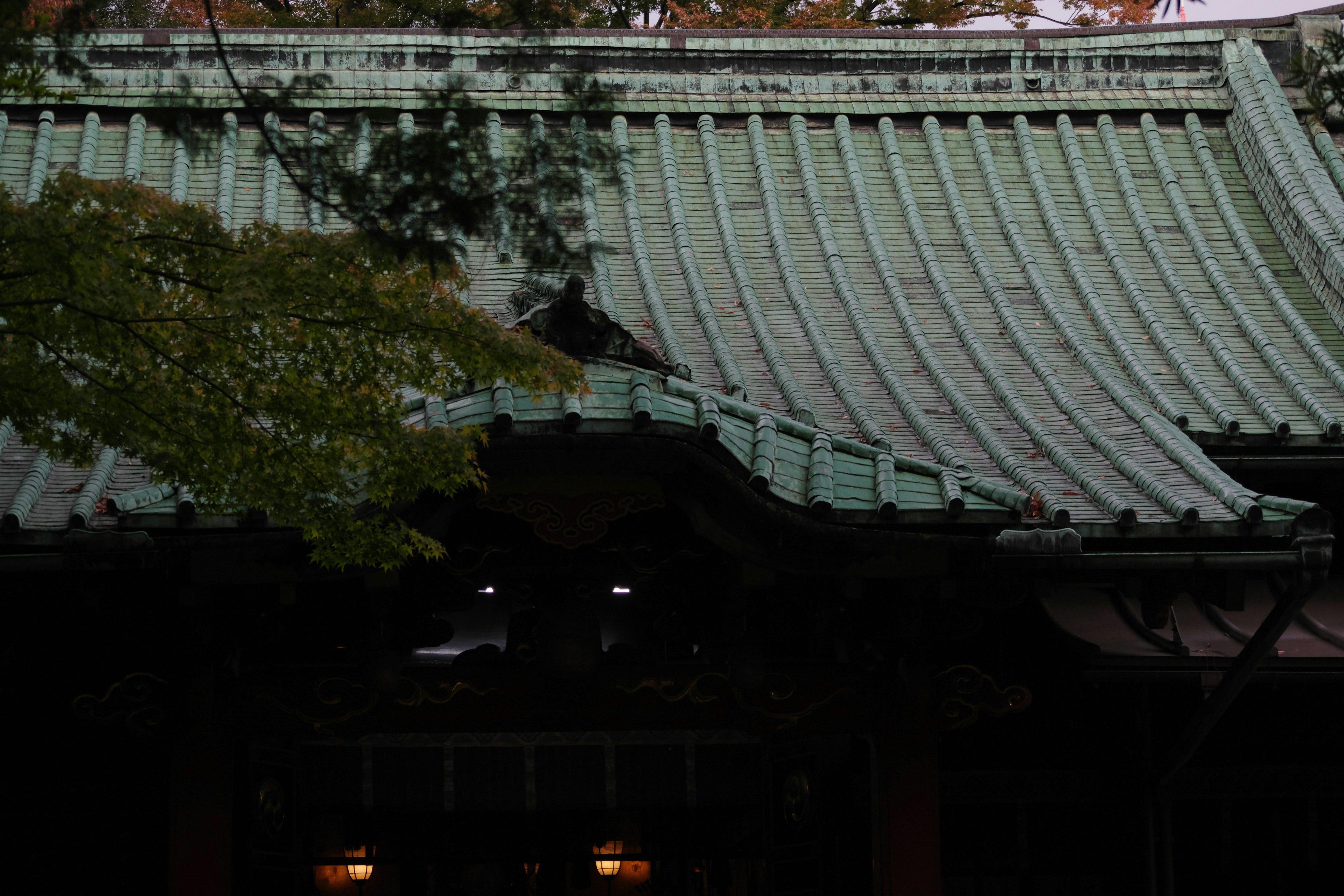 Parte de un edificio japonés tradicional con un techo verde