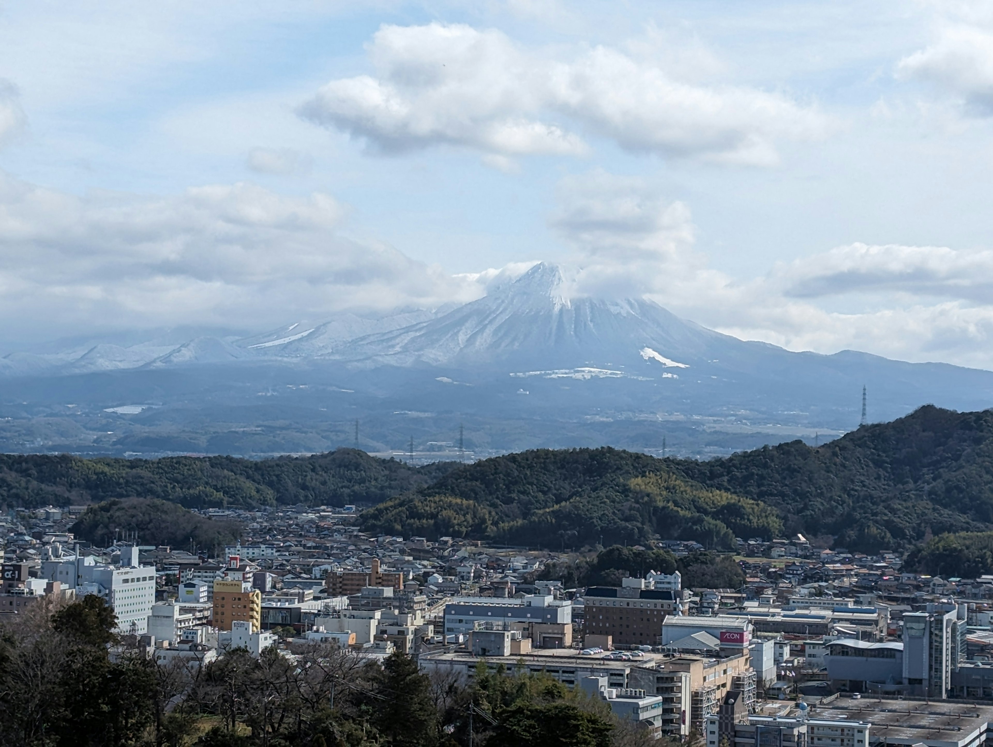 山と町の景色 雪のある山が背景 町の建物が見える