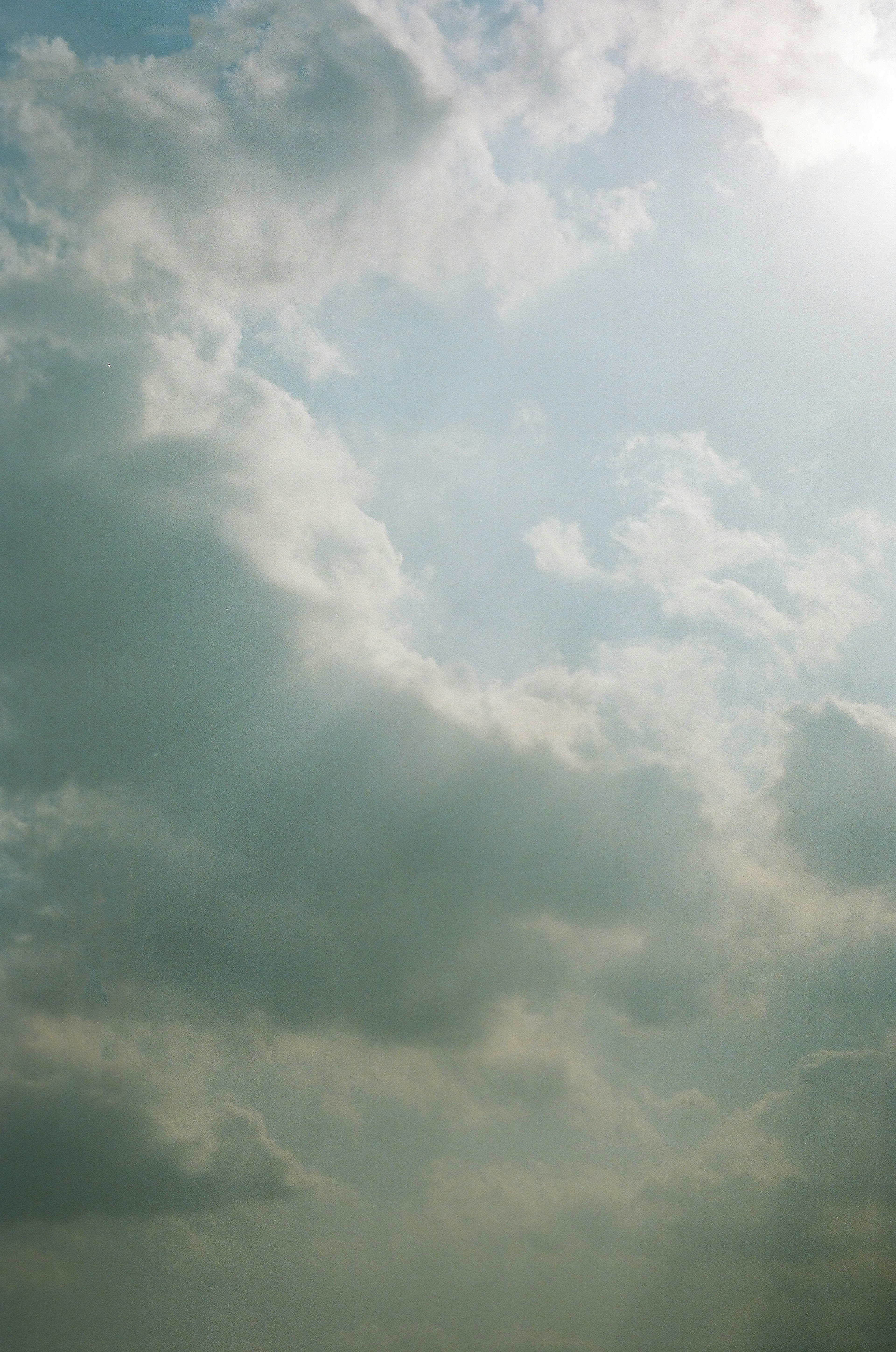 Awan lembut melayang di langit biru dengan cahaya lembut