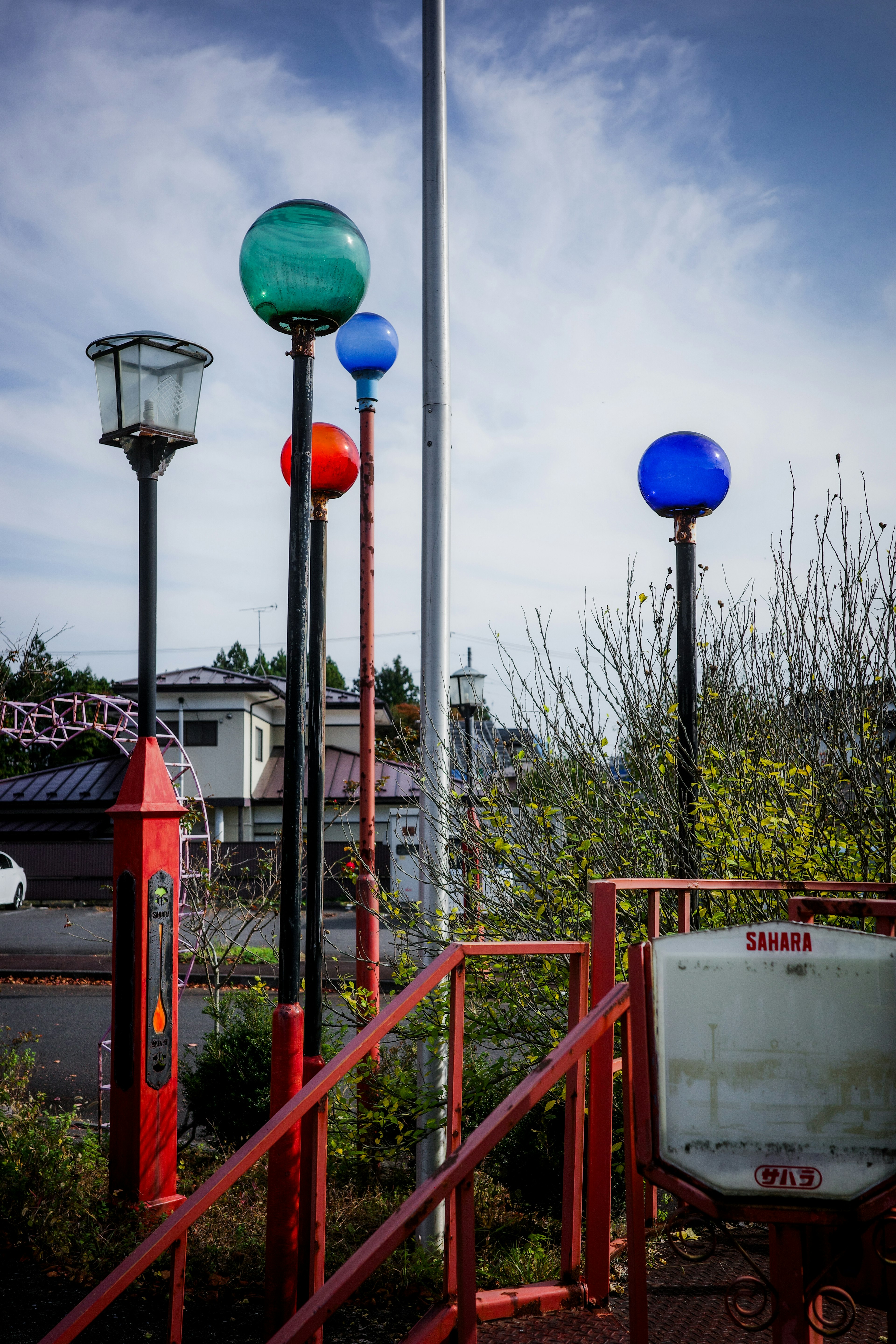 Escena de parque con lámparas coloridas y barandillas rojas