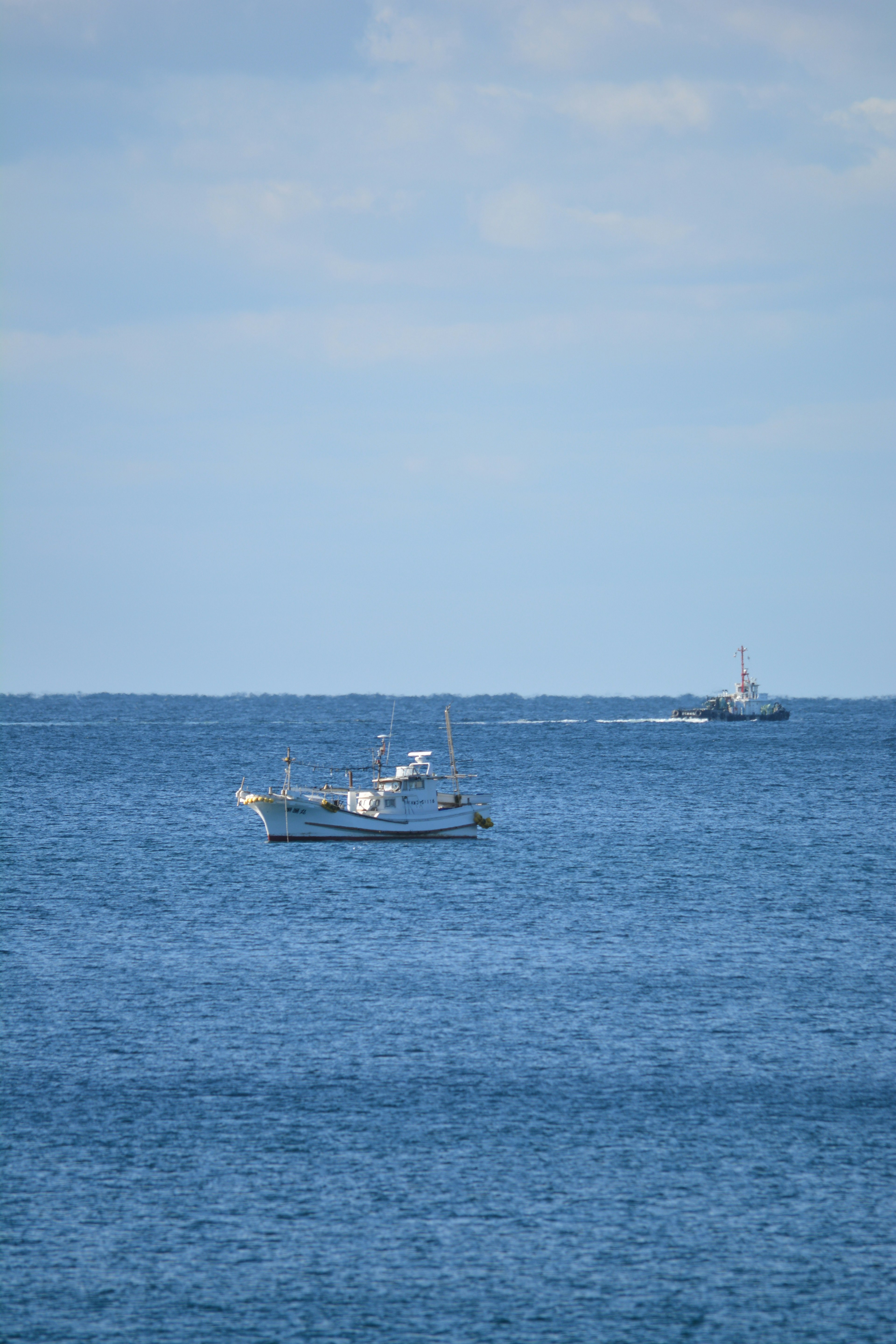 Fishing boats on a blue ocean with distant vessels