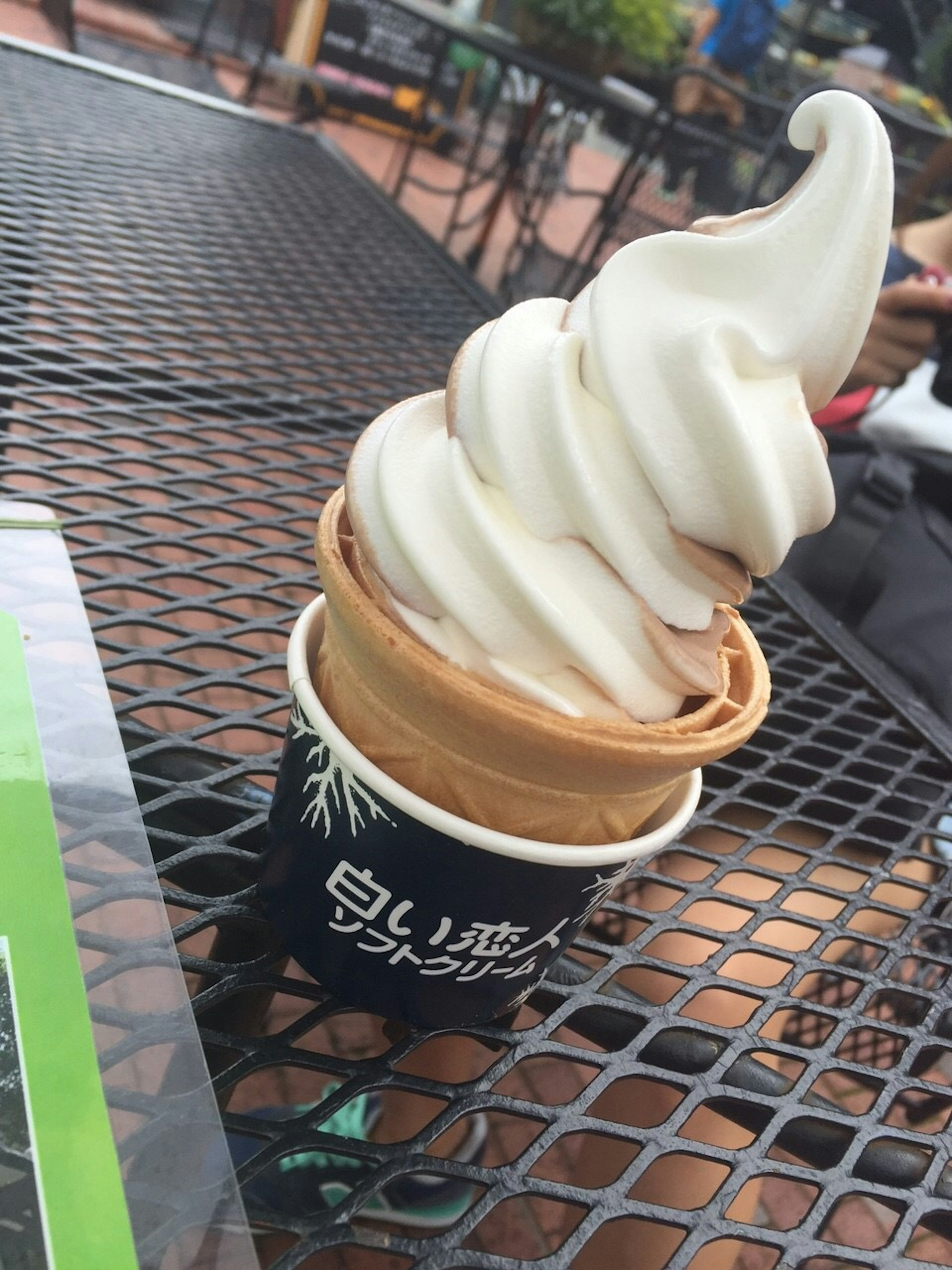 Soft serve ice cream in a cone with a creamy swirl on top