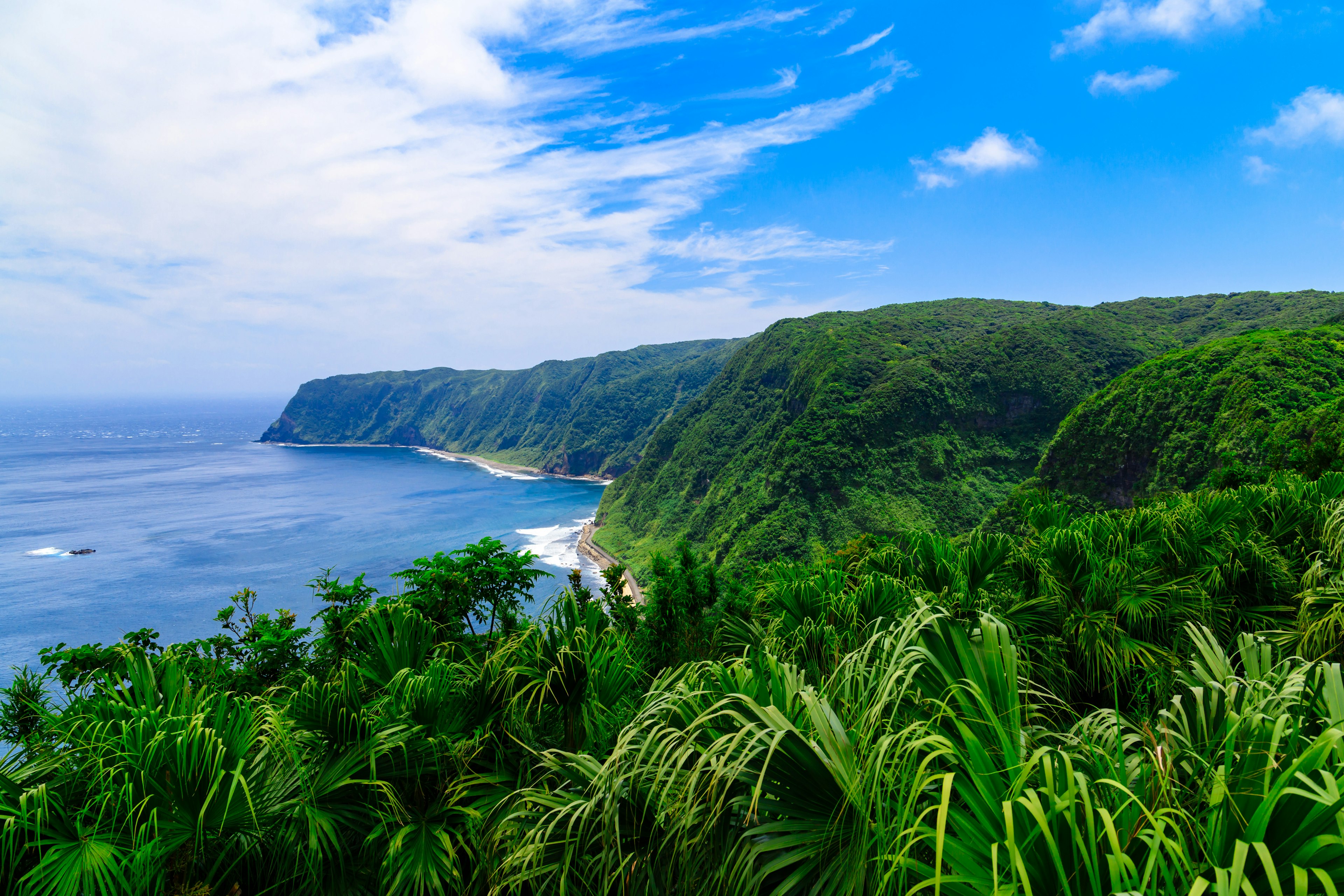 青空と緑の山々を背景にした海岸の美しい風景