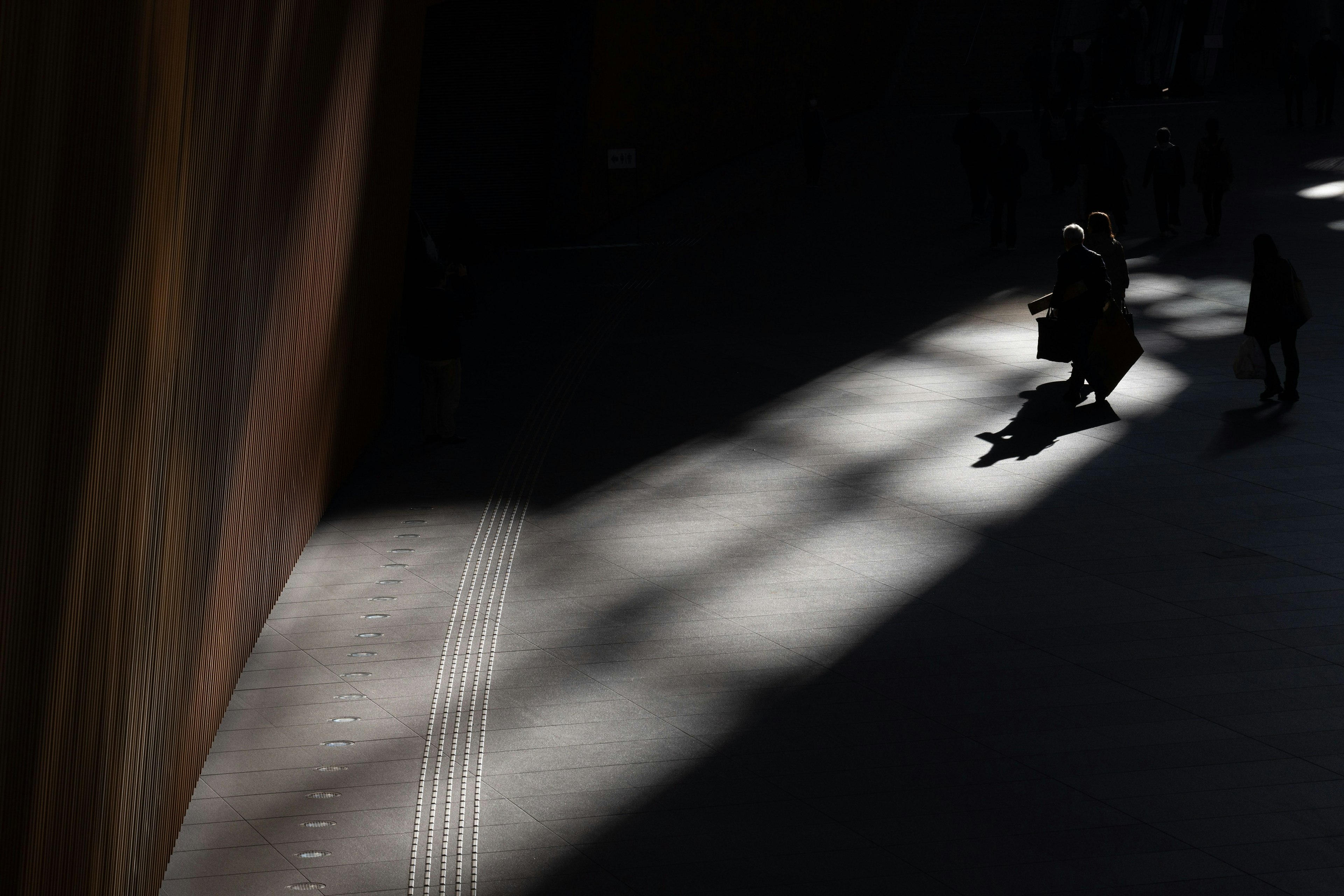 Des personnes se tenant dans un espace avec un beau contraste d'ombres et de lumière