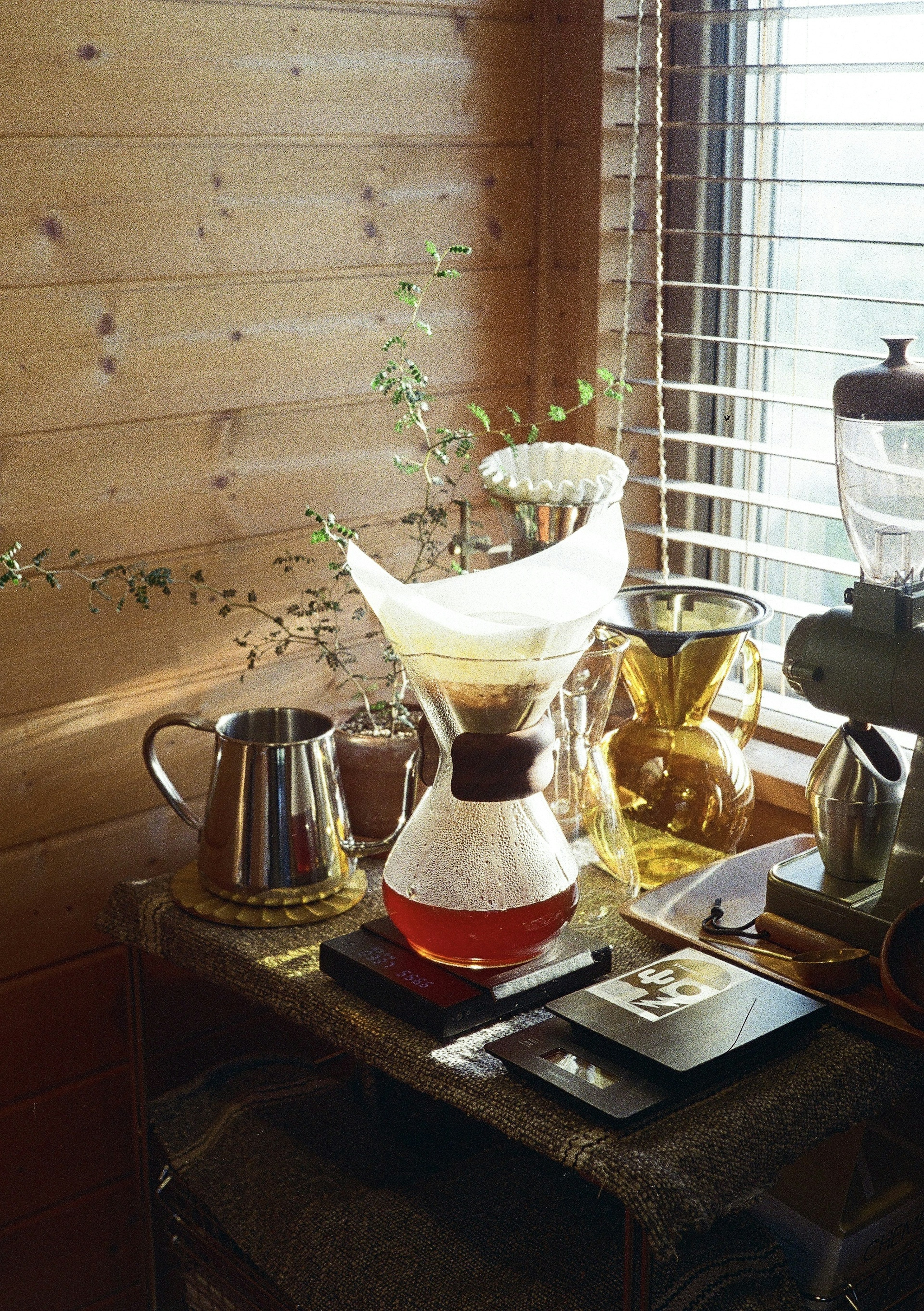 Coffee brewing setup with glass carafe and kettle on a wooden table