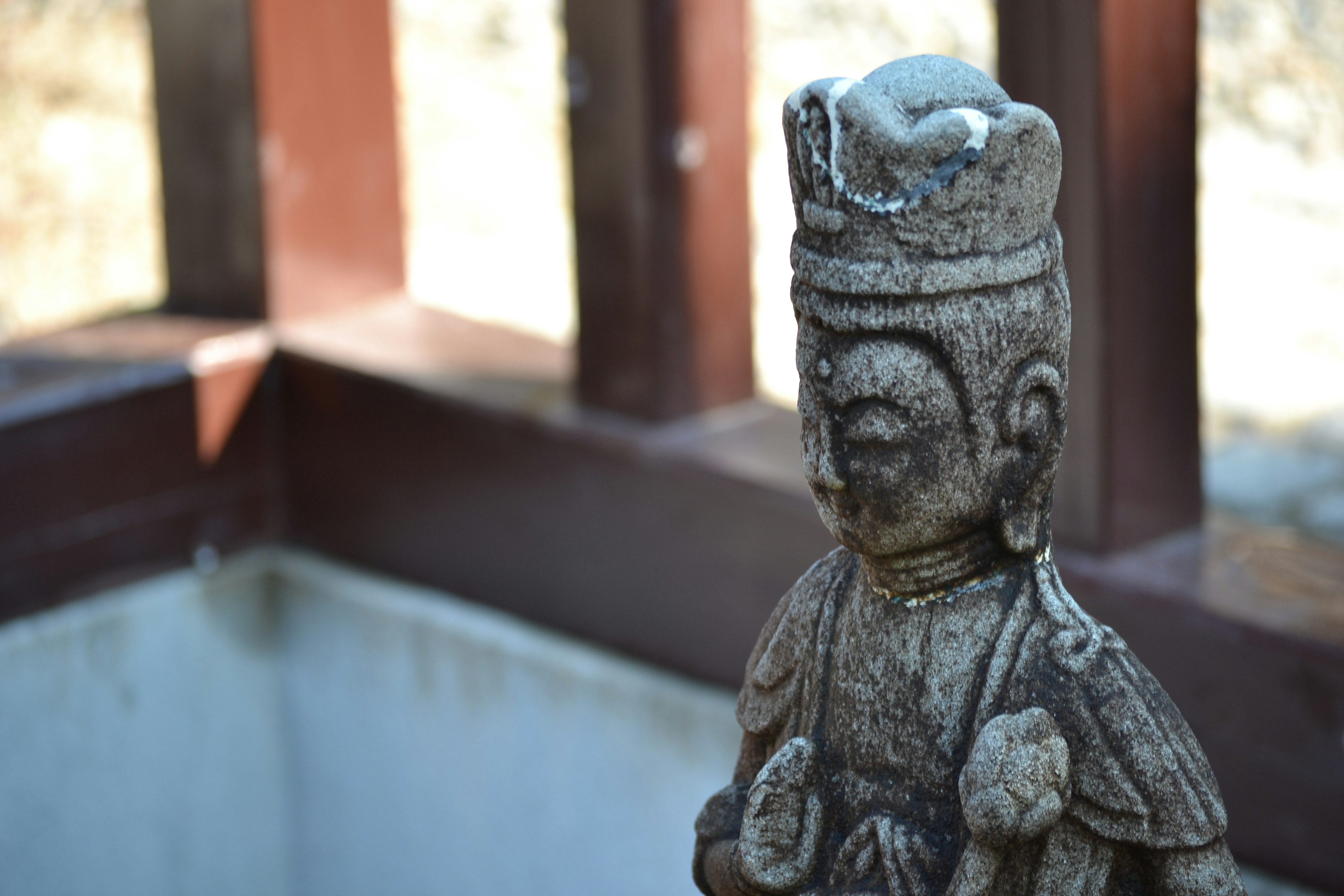 Una antigua estatua de piedra se encuentra en un jardín