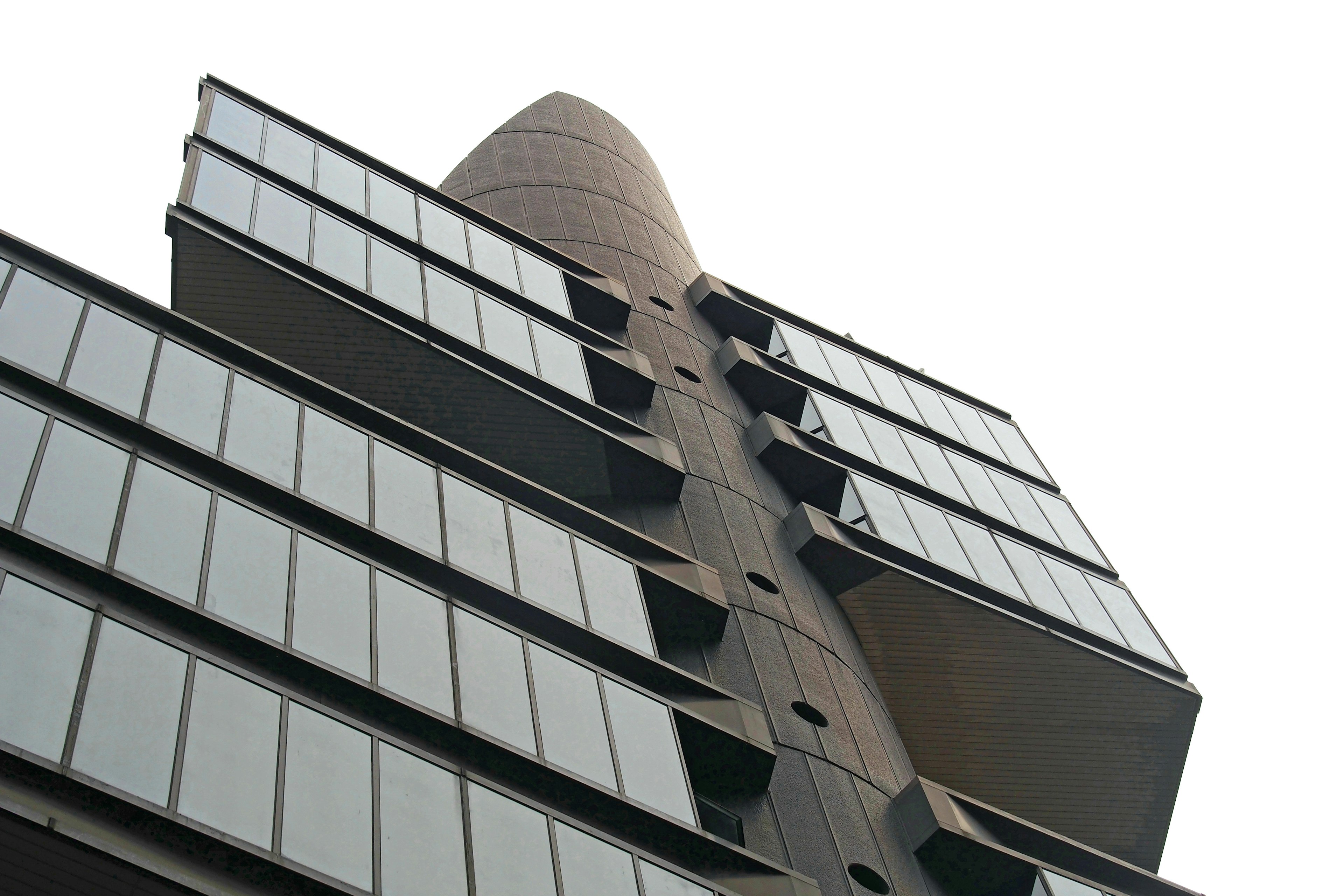 Edificio moderno con fachada alargada y balcones de vidrio