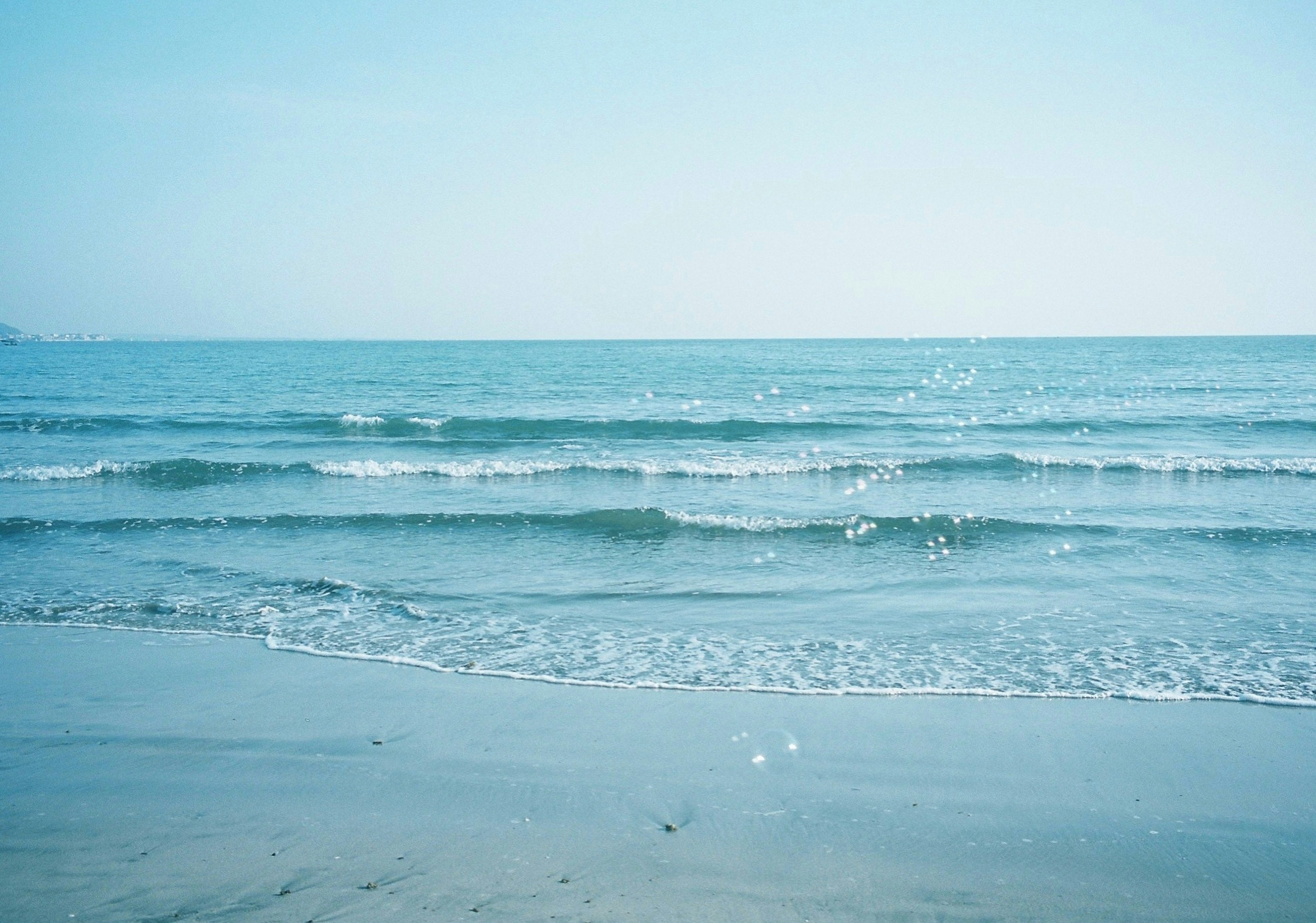 穏やかな波が打ち寄せる青い海の風景