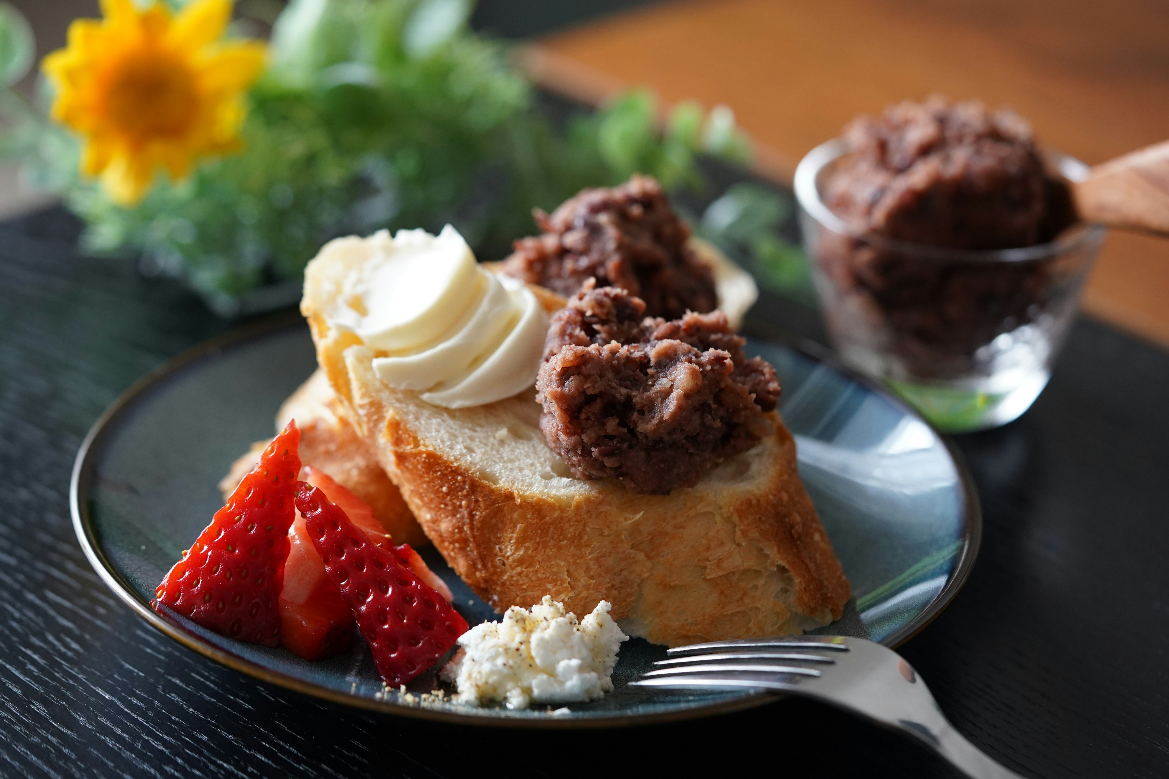 Plato de postre con pan dulce cubierto de plátano y pasta de frijol rojo