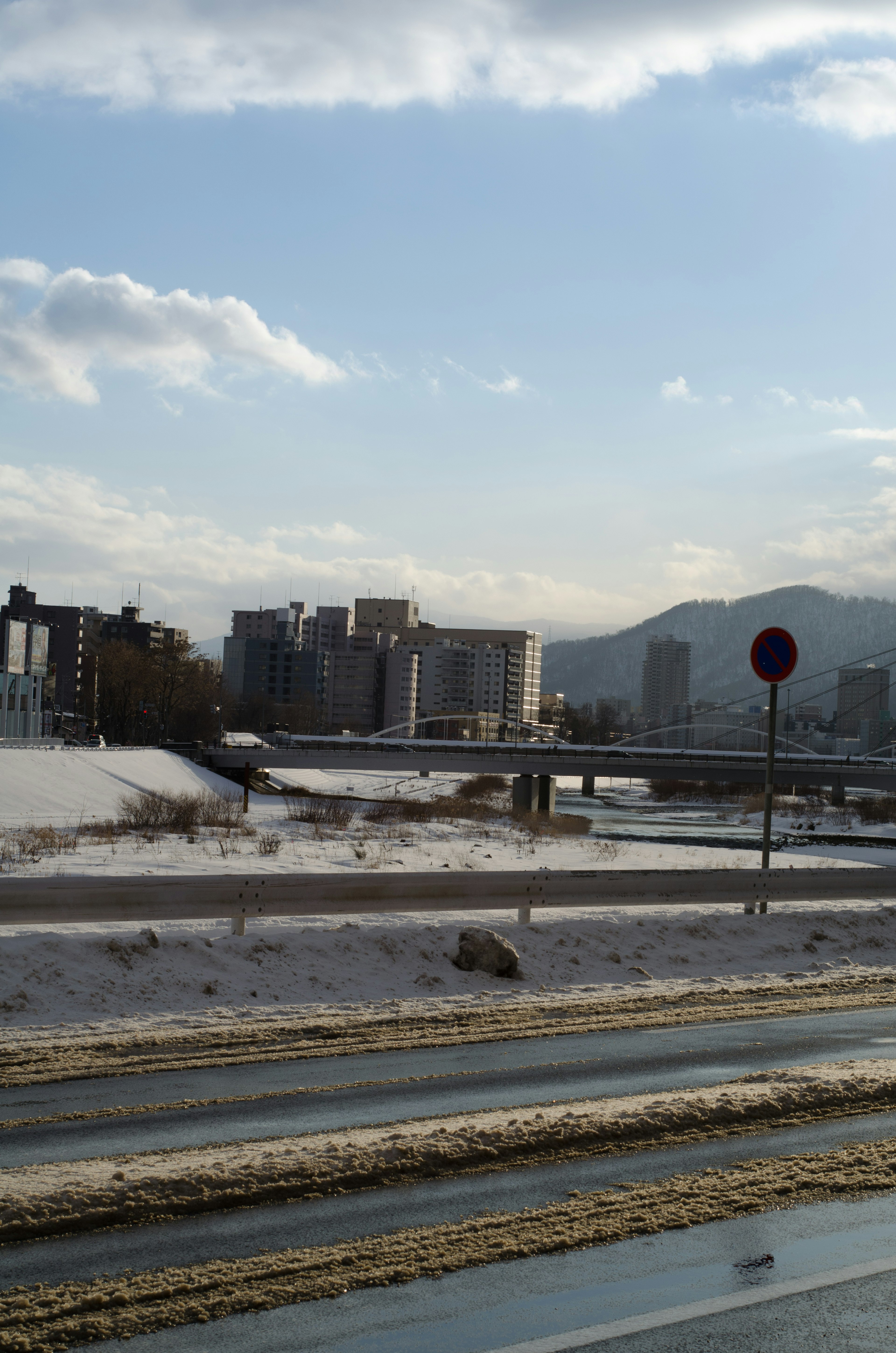 Escena invernal con camino cubierto de nieve y edificios