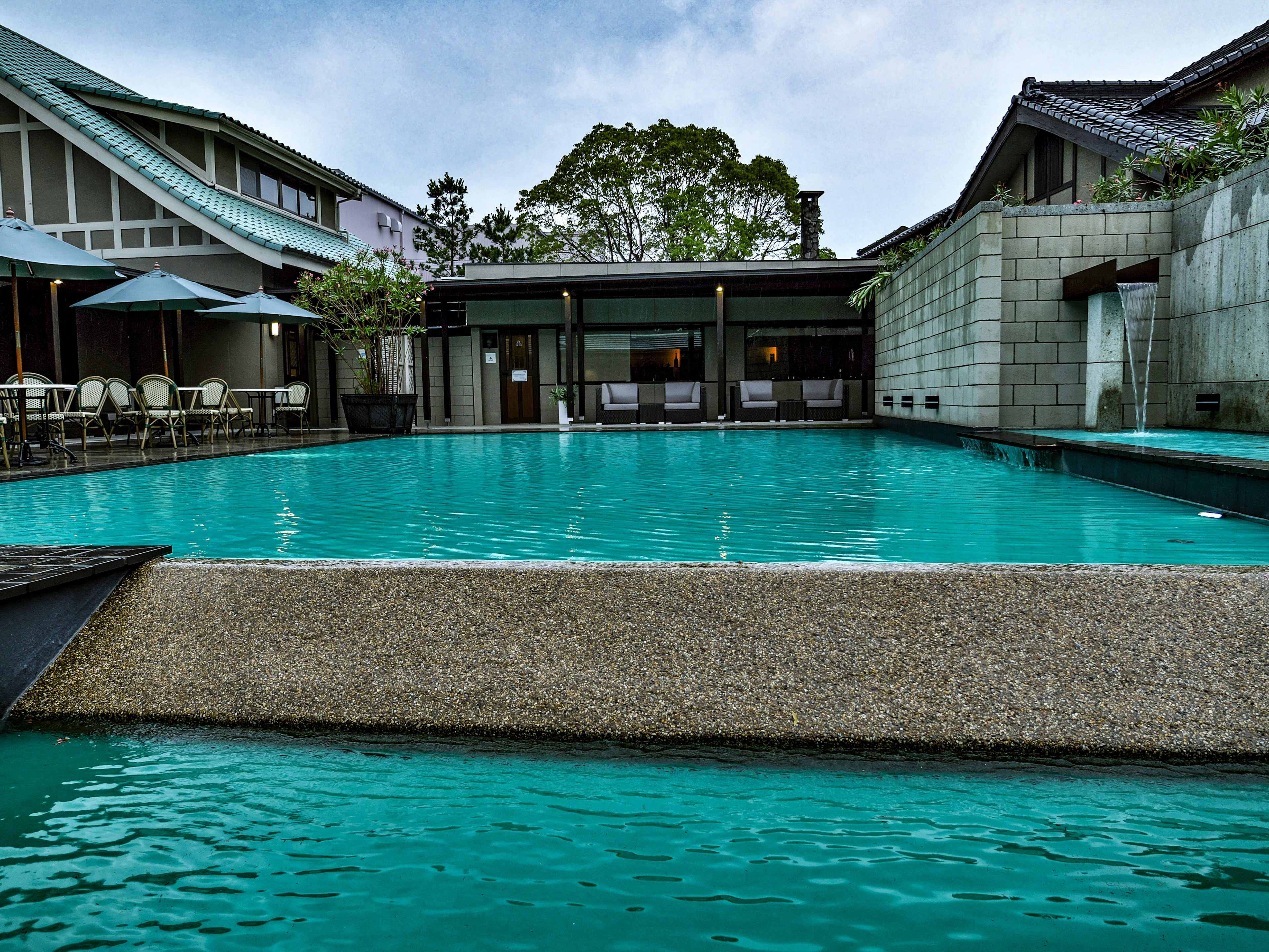 Une zone de piscine sereine avec de l'eau turquoise et une architecture moderne