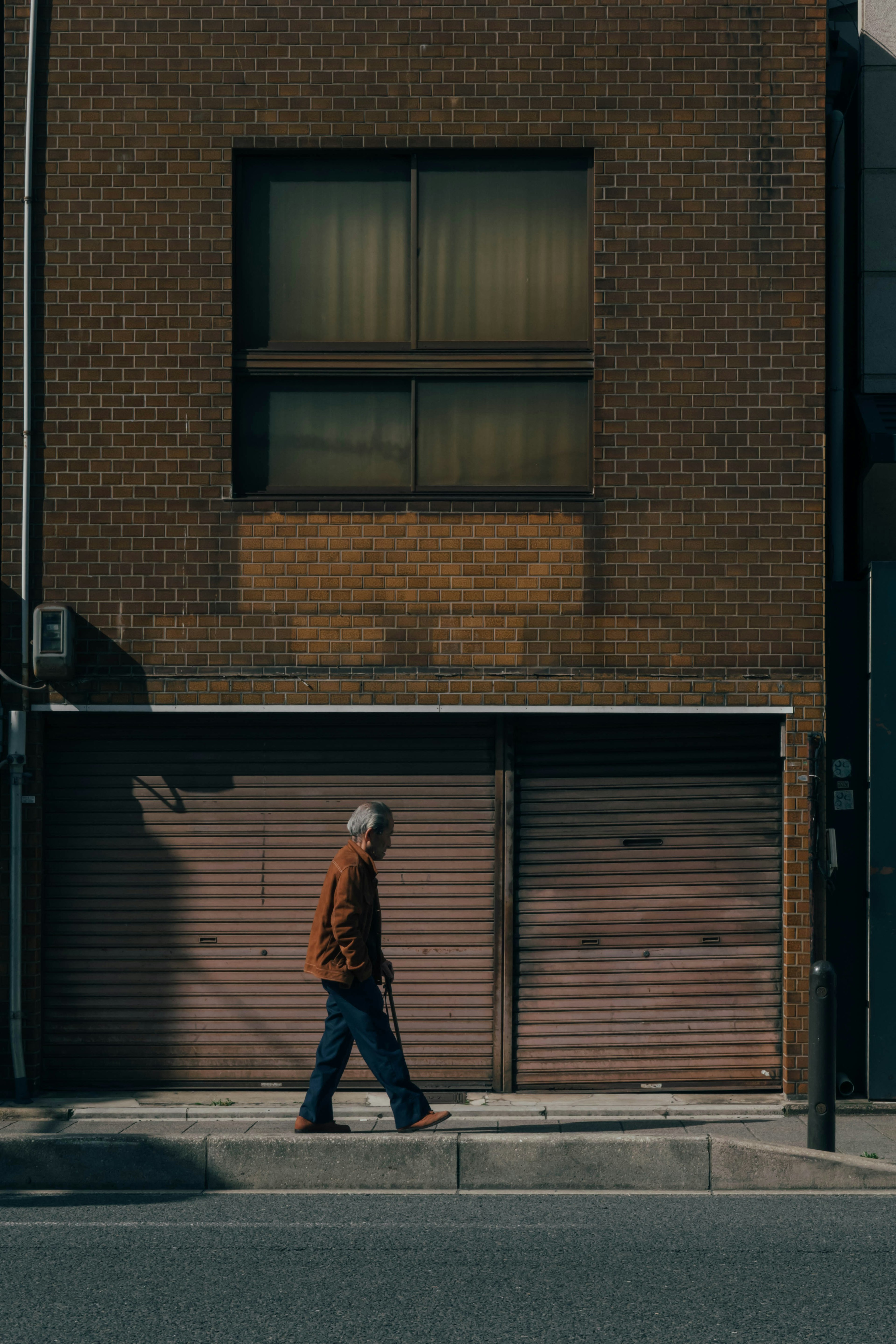 A man walking in front of an old brick building