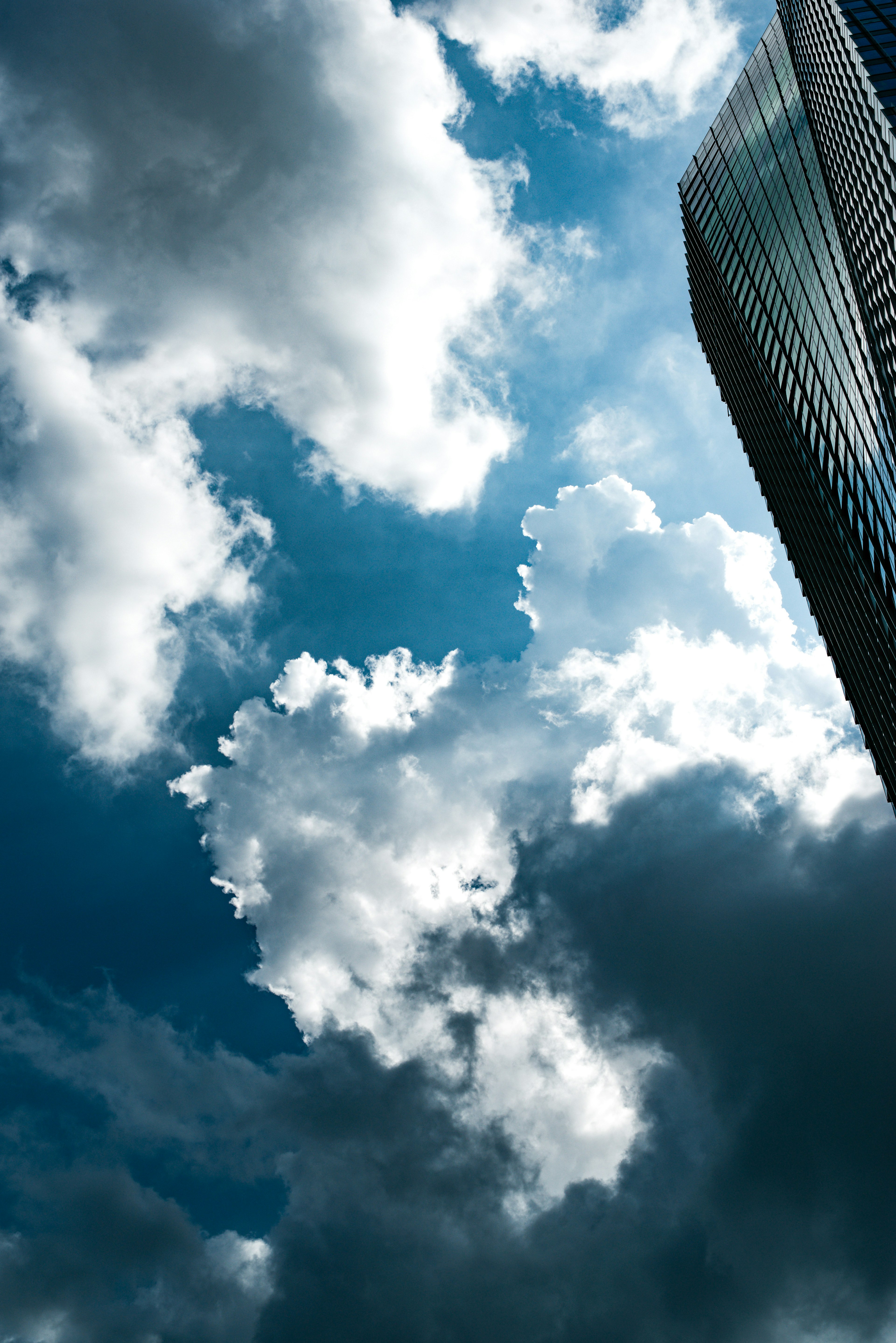 Hochhaus vor einem Hintergrund aus weißen Wolken und blauem Himmel