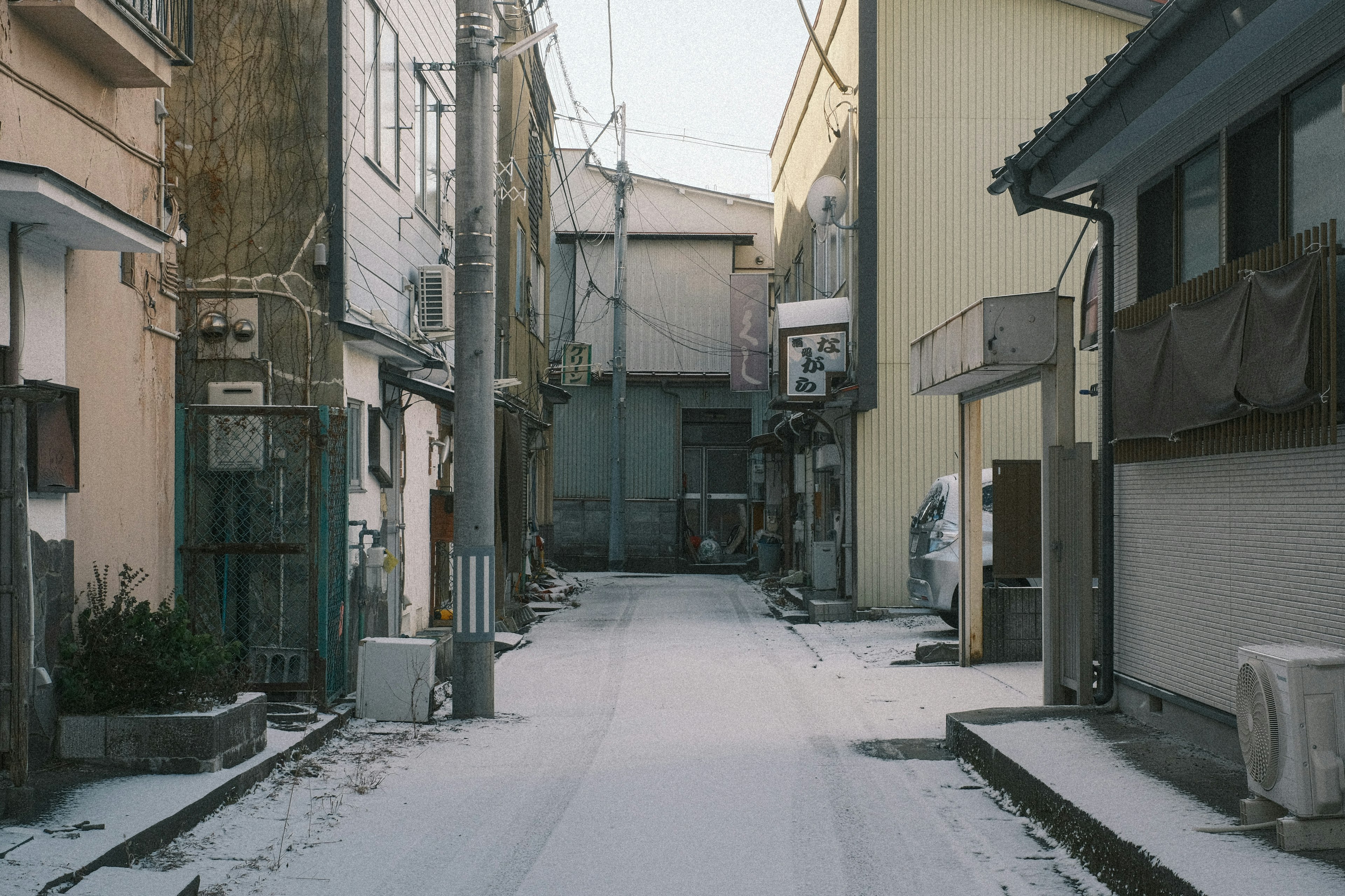 Escena de calle tranquila con suelo cubierto de nieve y edificios antiguos