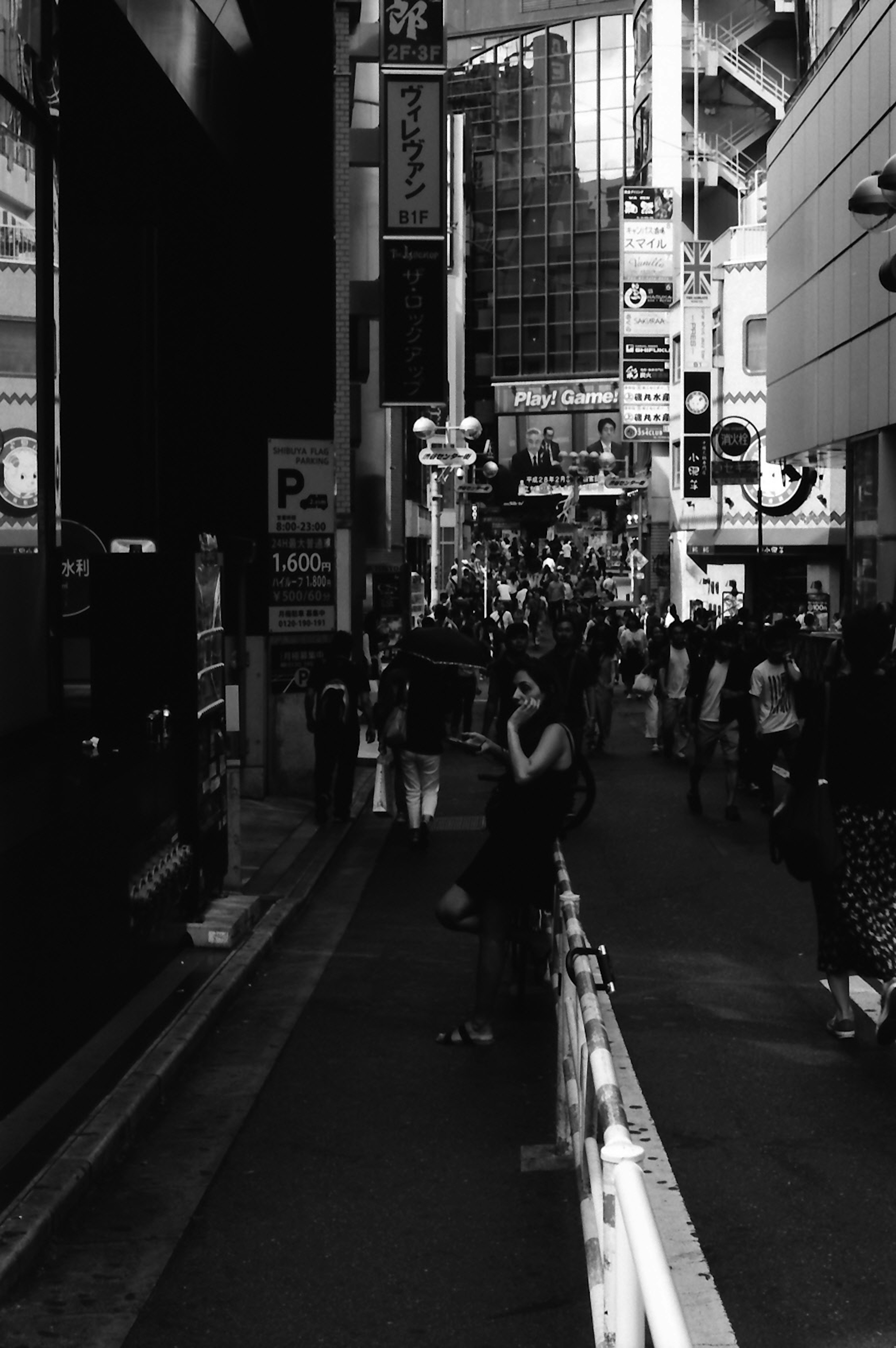 Escena urbana en blanco y negro con una calle bulliciosa y gente