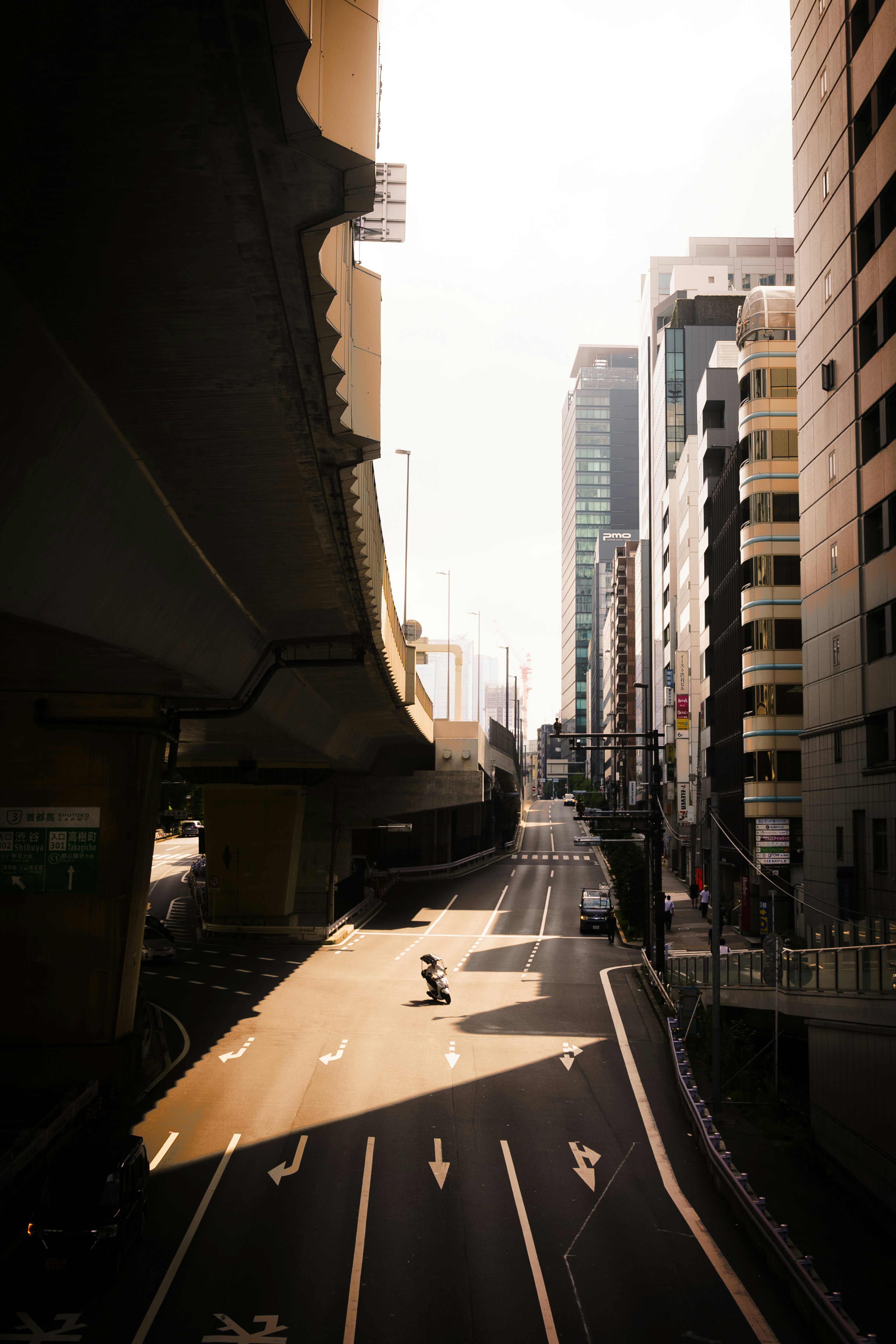 Urban scene featuring an empty road and shadows from an overpass