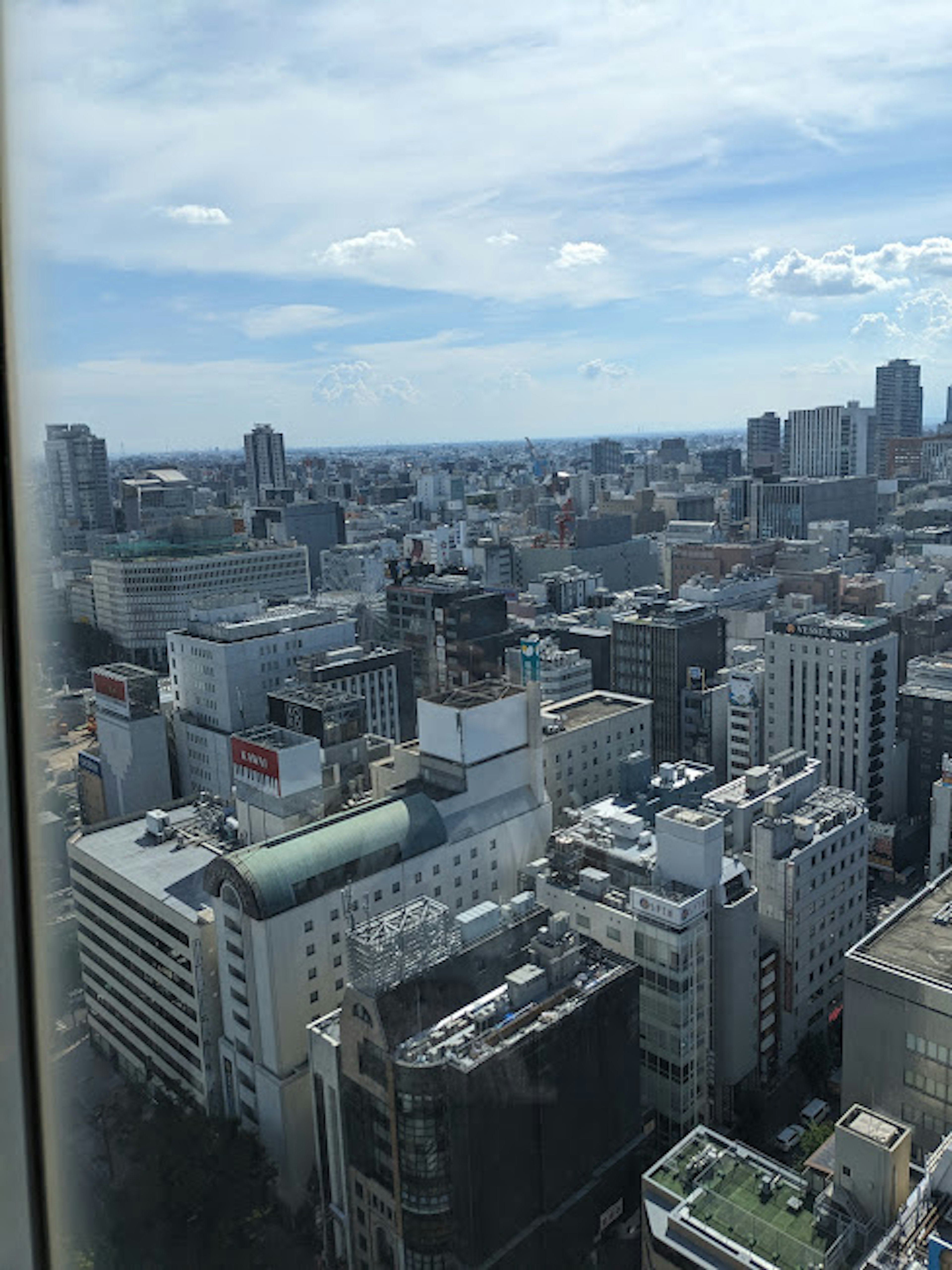 City skyline view from a high-rise building with blue sky and clouds