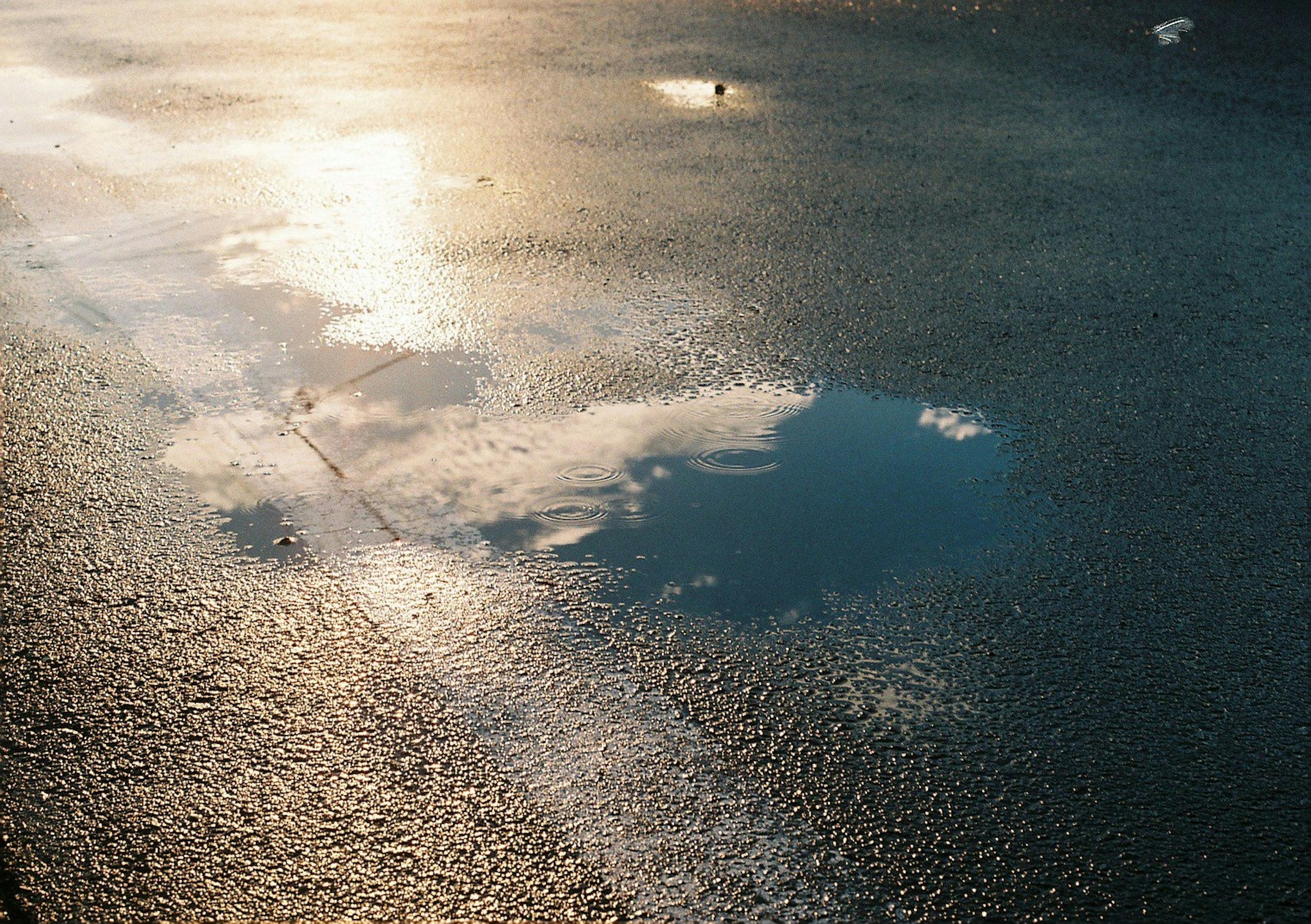 宁静的湖面景象，水面上映出的云朵和光线的反射