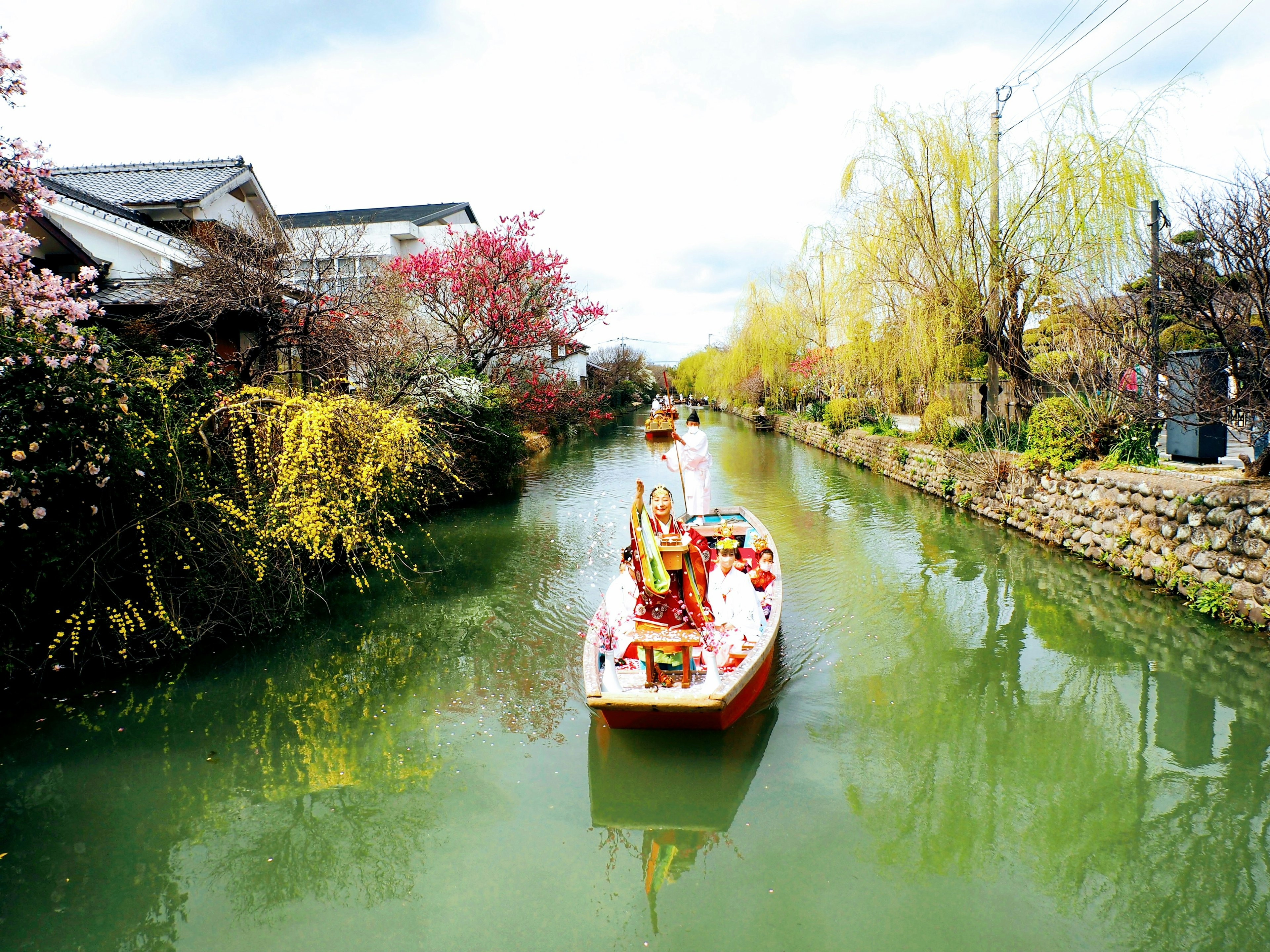 Ein malerischer Kanal mit bunten Blumen und einem Boot, das über das Wasser gleitet