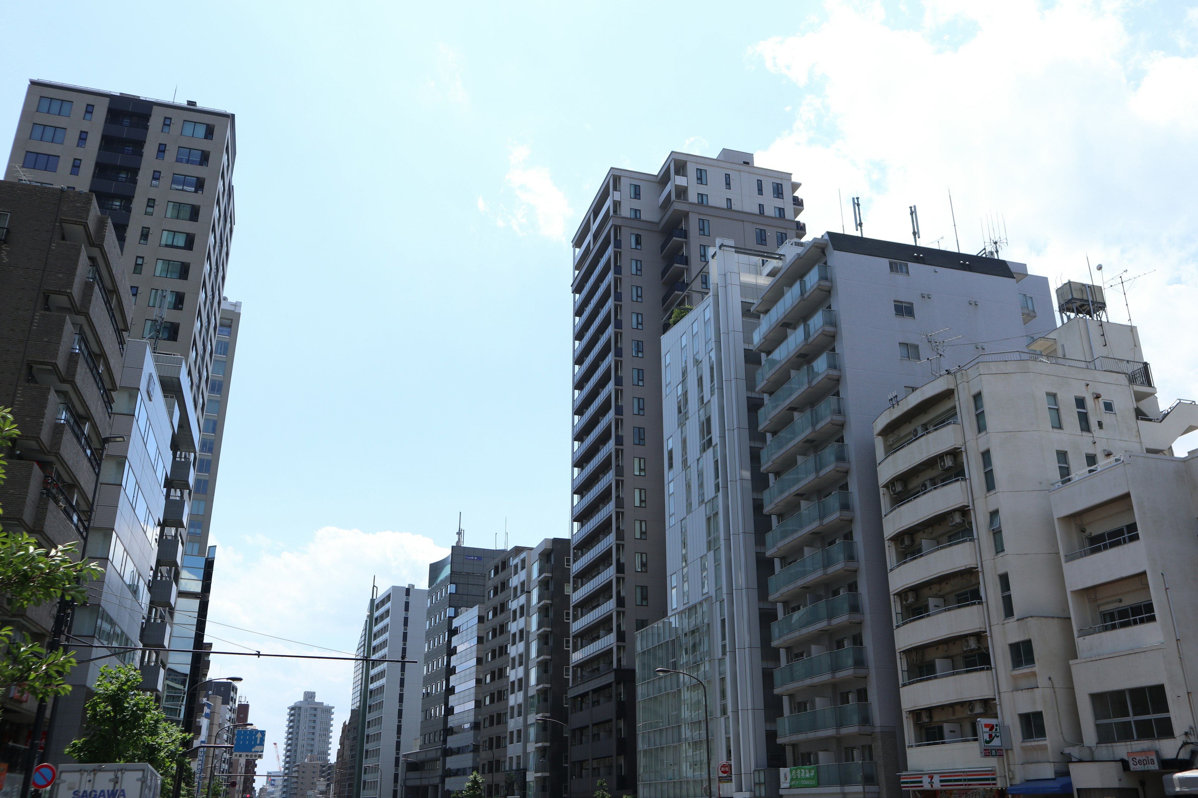 Urban landscape with skyscrapers under a clear blue sky and clouds