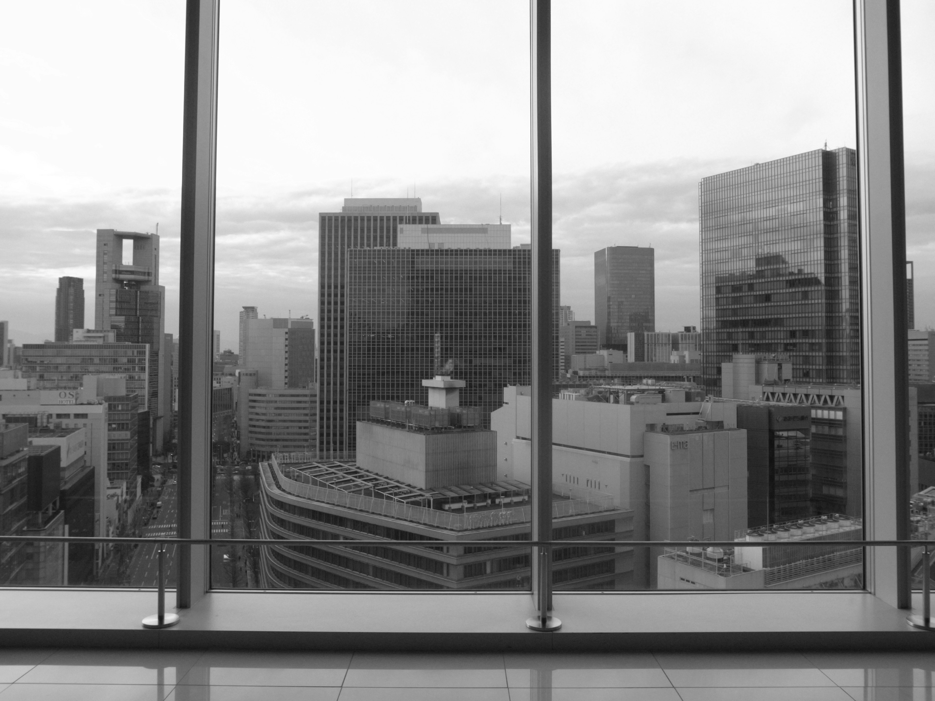 Black and white view of urban skyscrapers through large windows