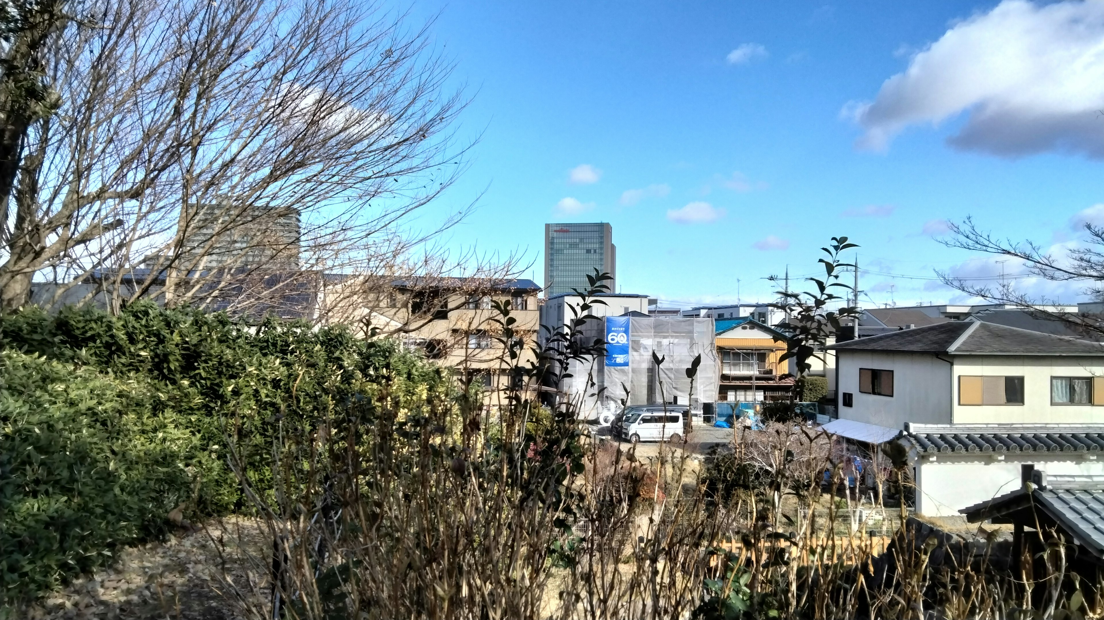 Blick auf Gebäude unter einem klaren blauen Himmel mit Grünflächen und Wohngebieten