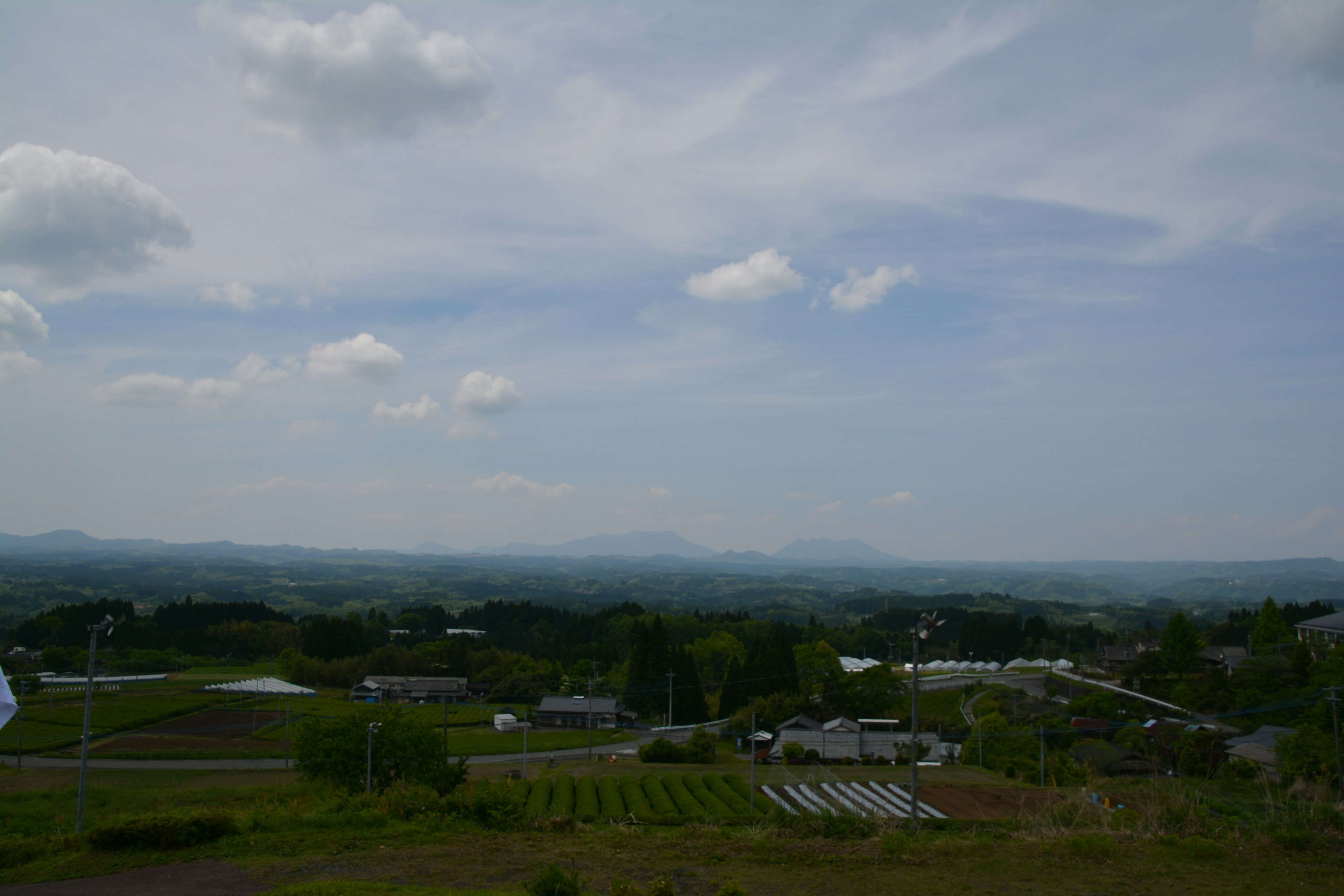 Weitläufige Landschaft mit grünen Feldern und blauem Himmel