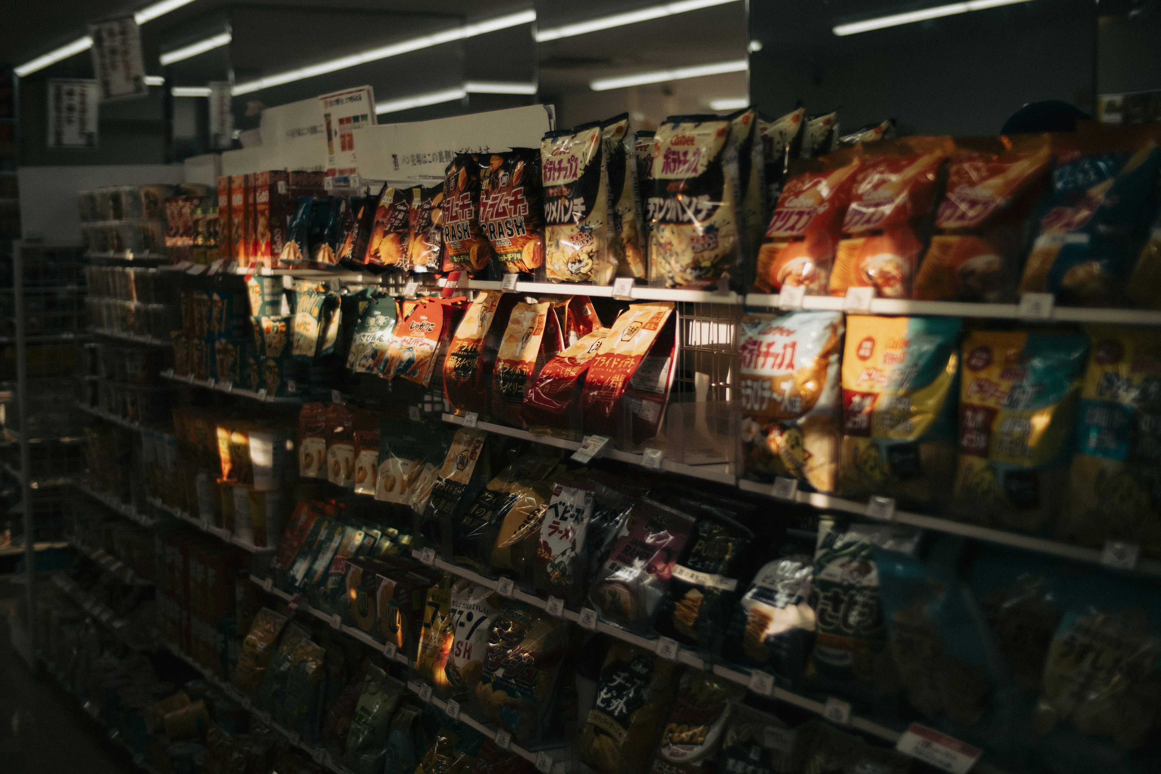 Uno scaffale pieno di sacchetti di snack in un negozio