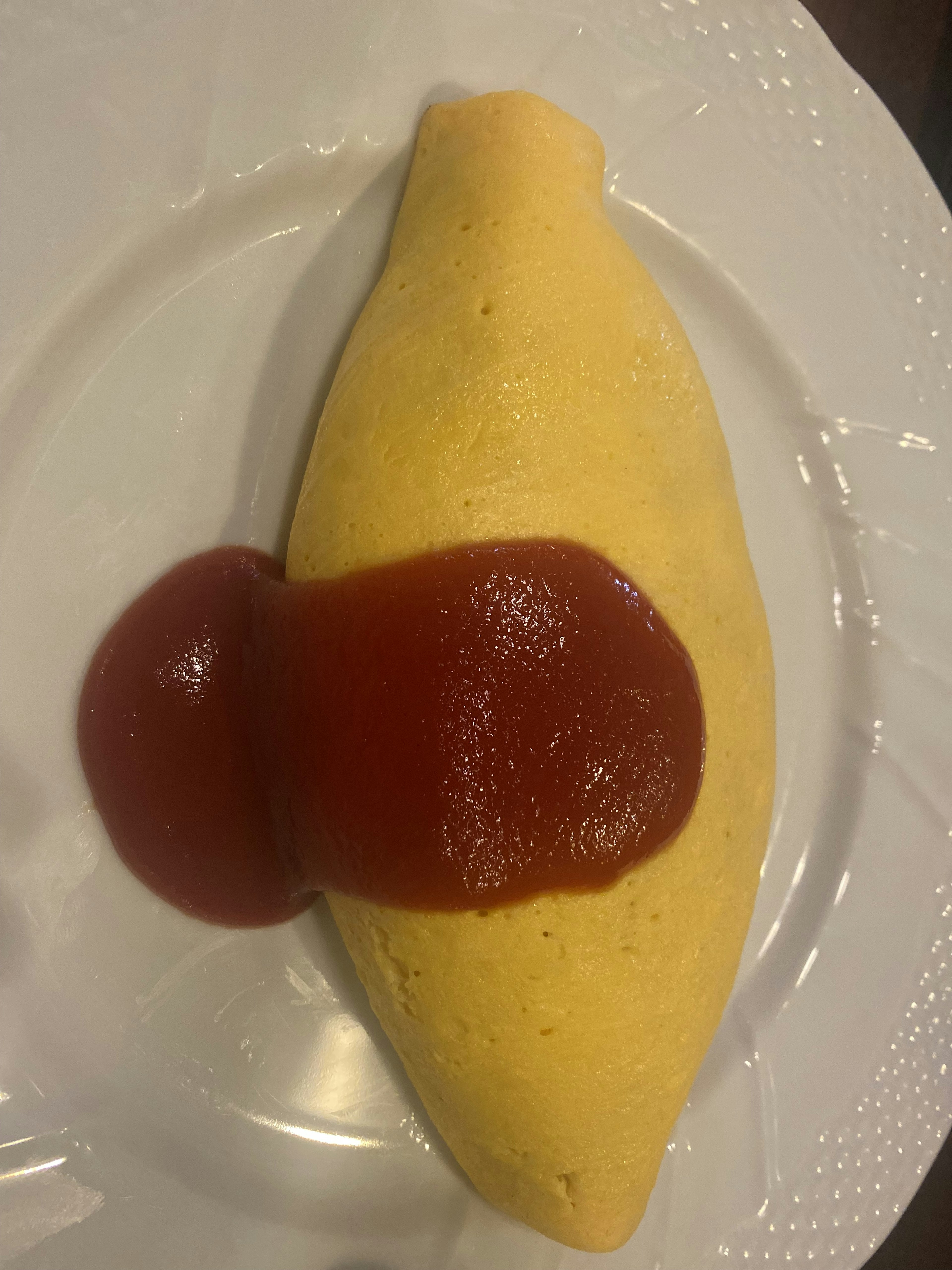 Omelette garnie de ketchup sur une assiette blanche