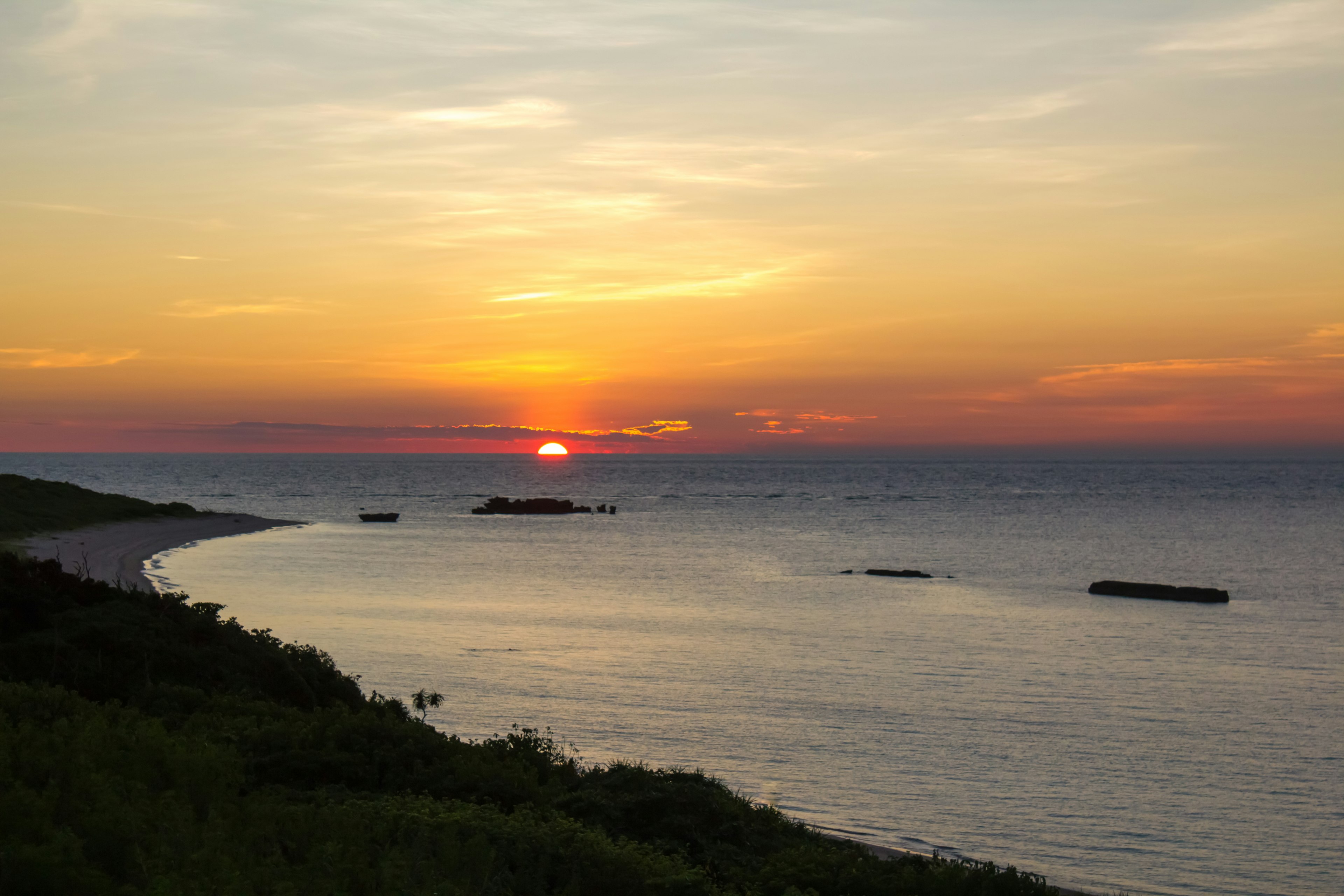 海上日落的美丽风景，绿草和宁静的波浪