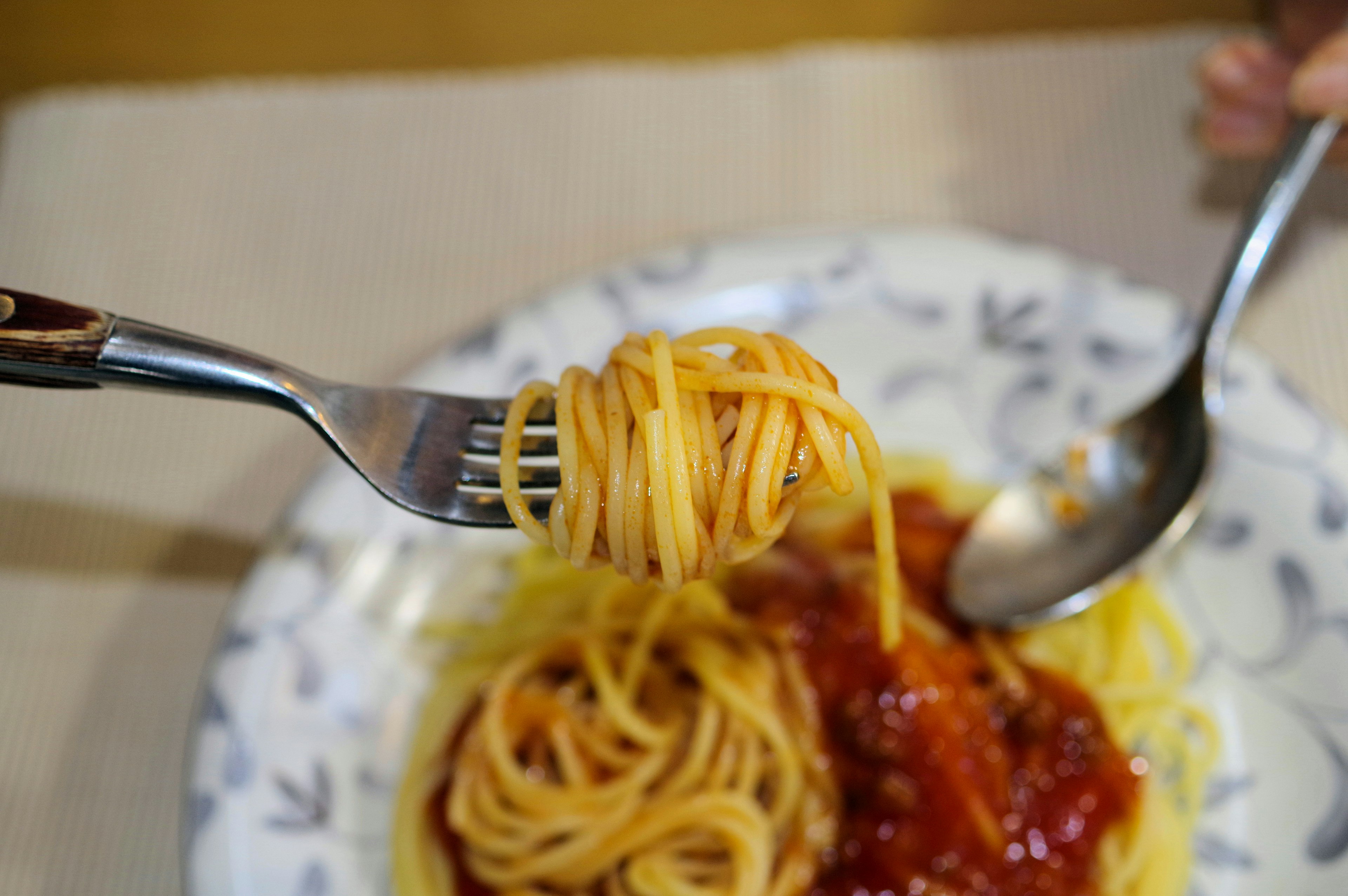 Fork with spaghetti and tomato sauce on a plate