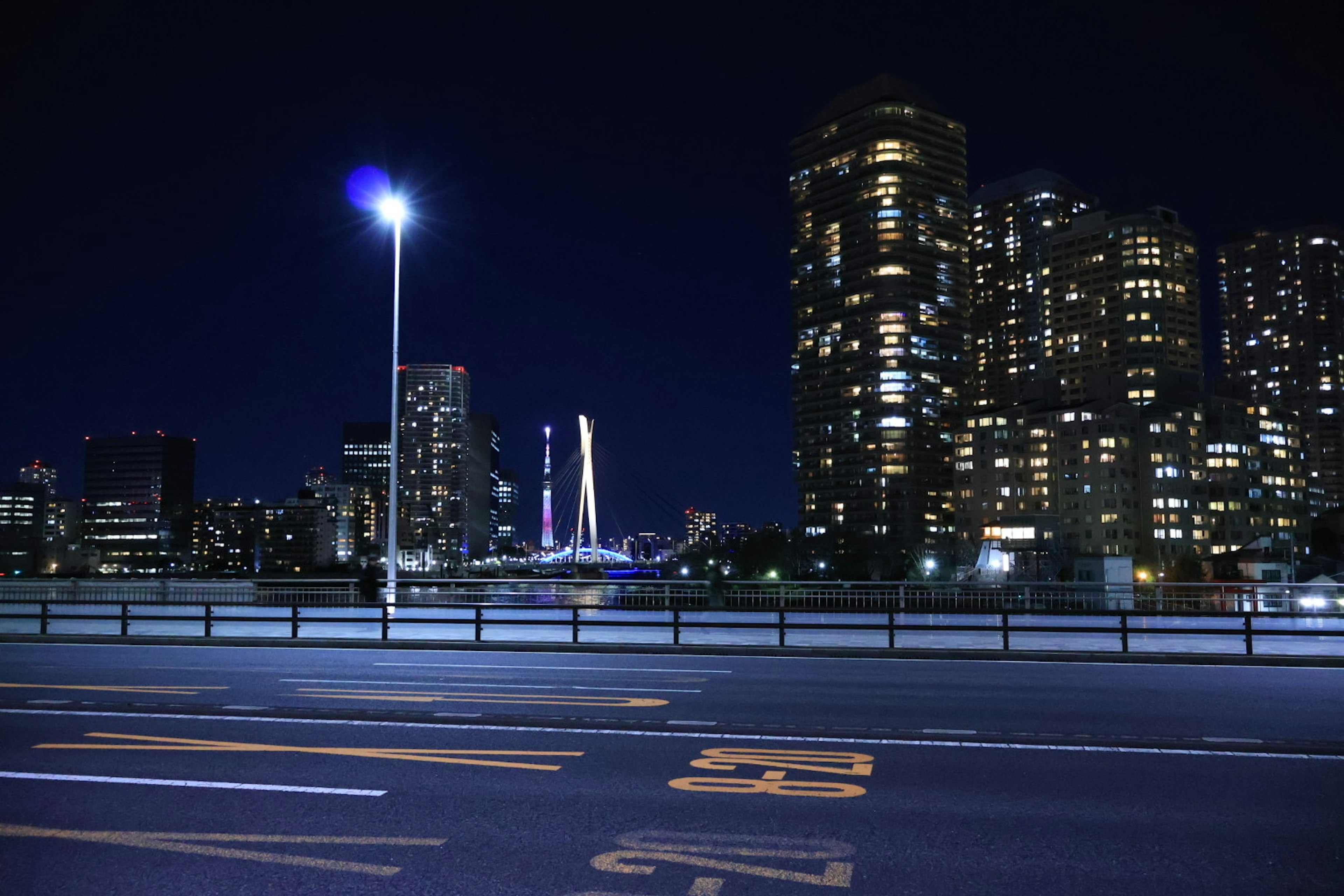 Paisaje urbano nocturno con rascacielos iluminados y un puente