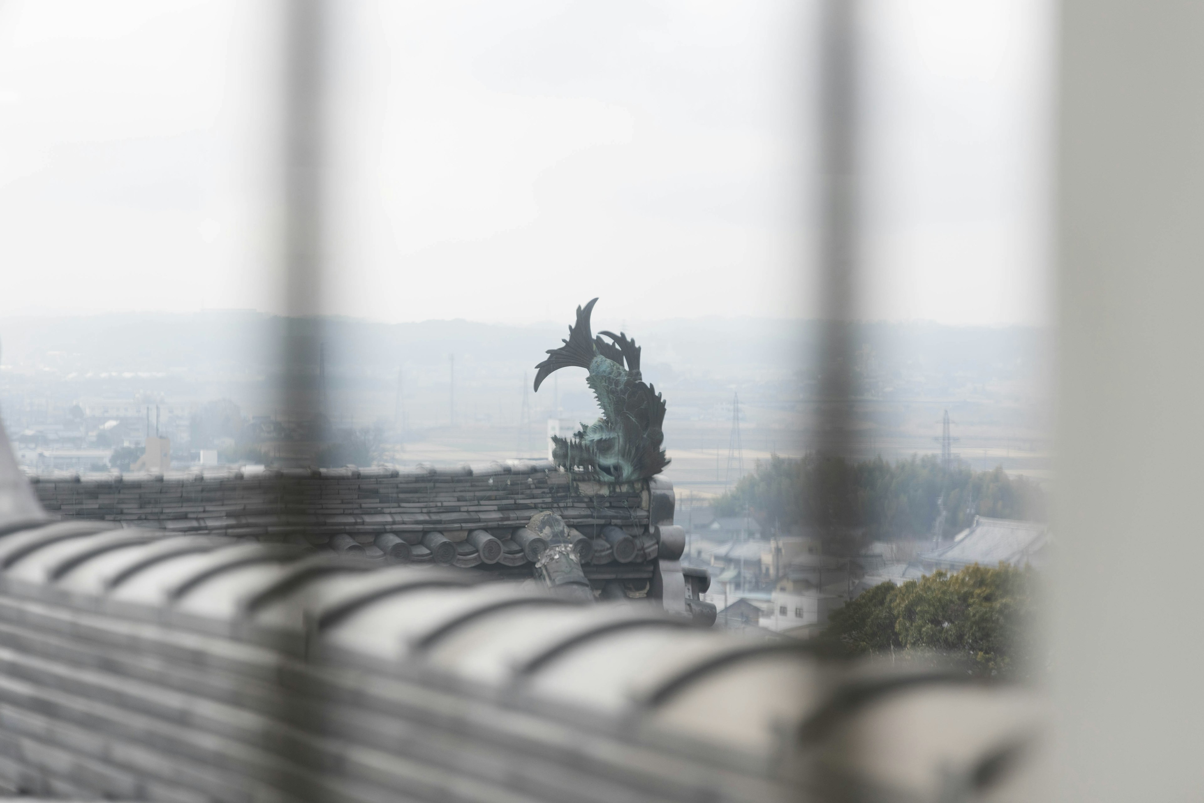 Eine Schlossmauer mit einer Skulptur, die durch ein Geländer sichtbar ist