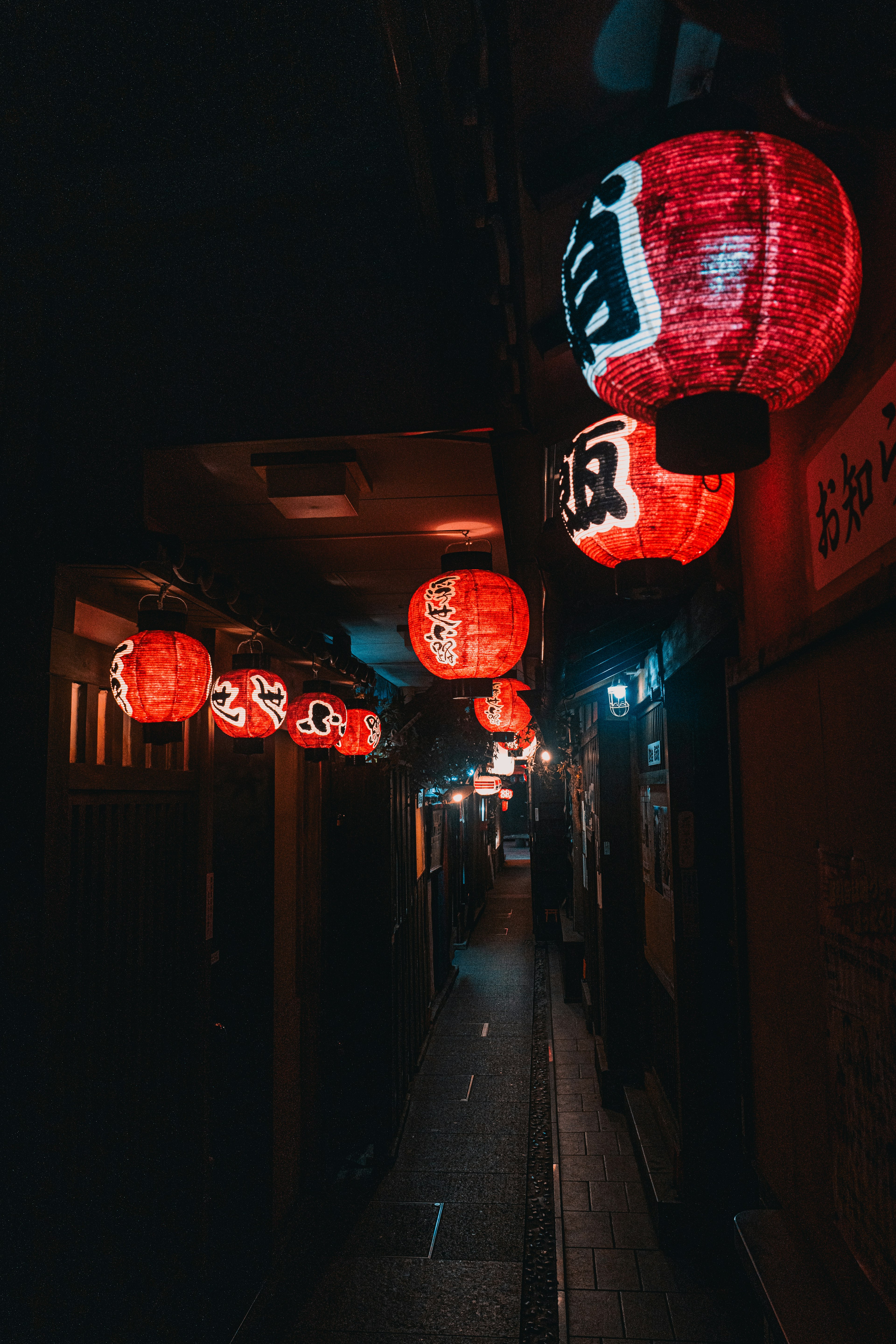 Lanternes rouges illuminant une ruelle sombre étroite