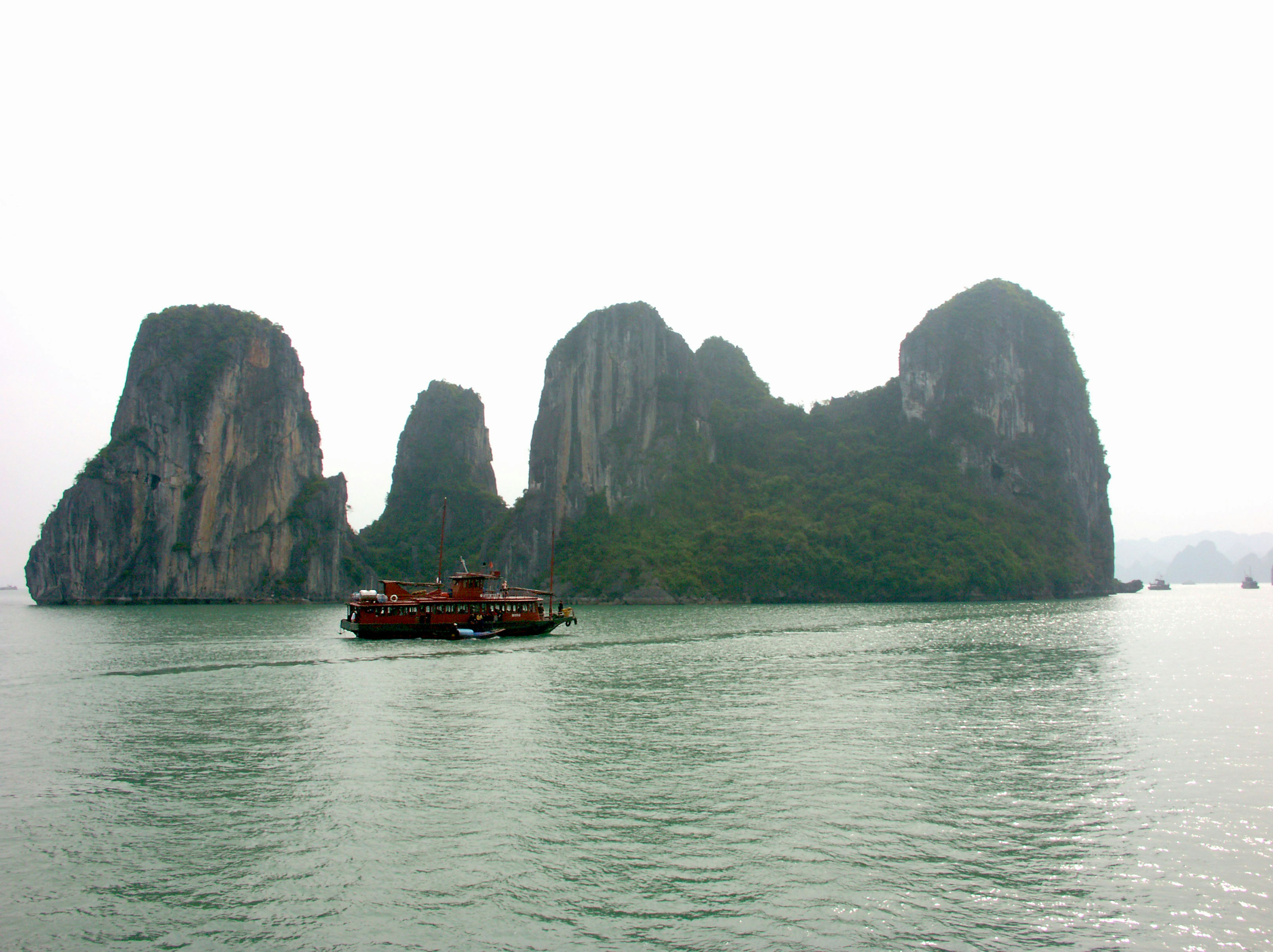 Foggy landscape with rock formations and a boat