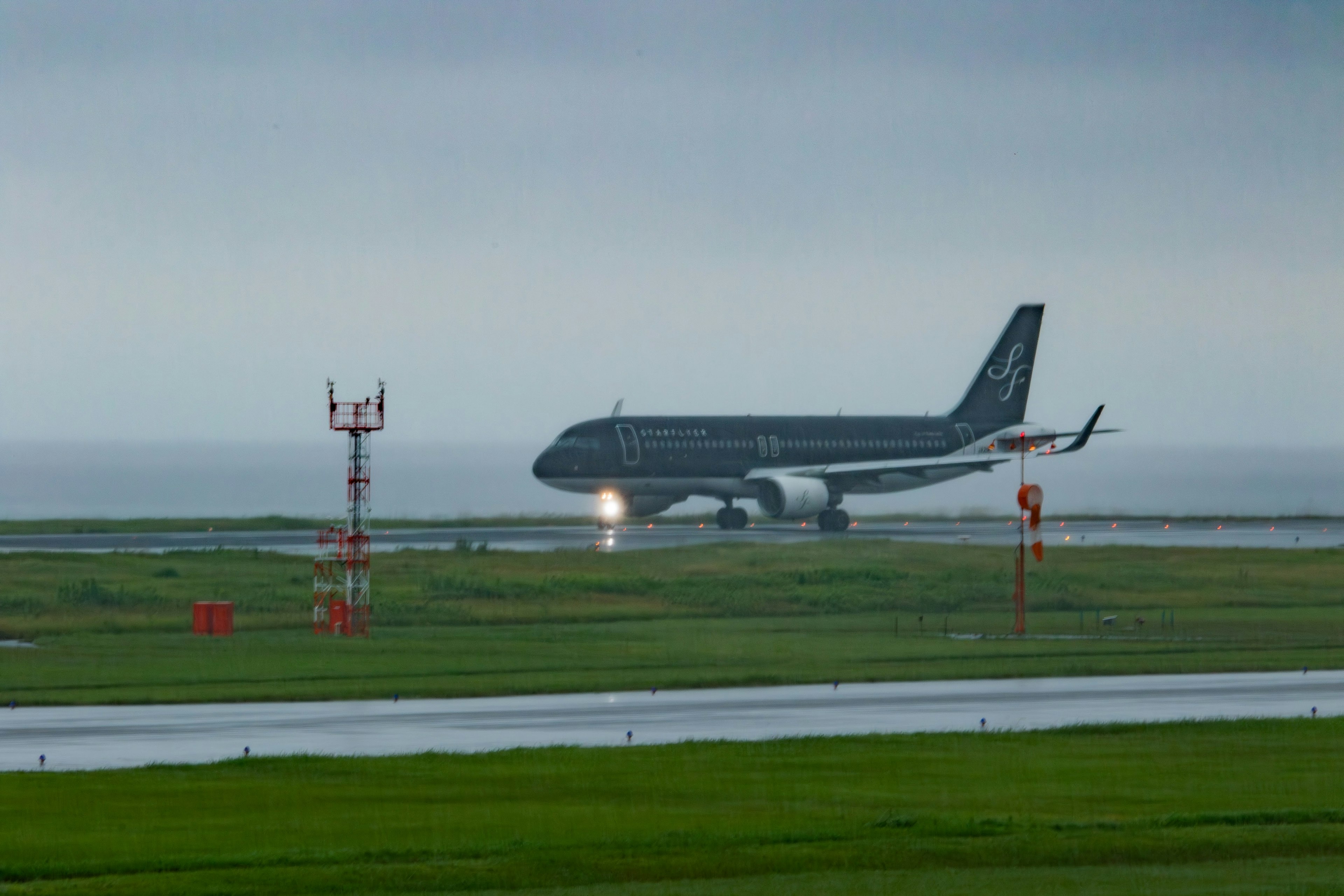 Avion atterrissant sur une piste sous la pluie