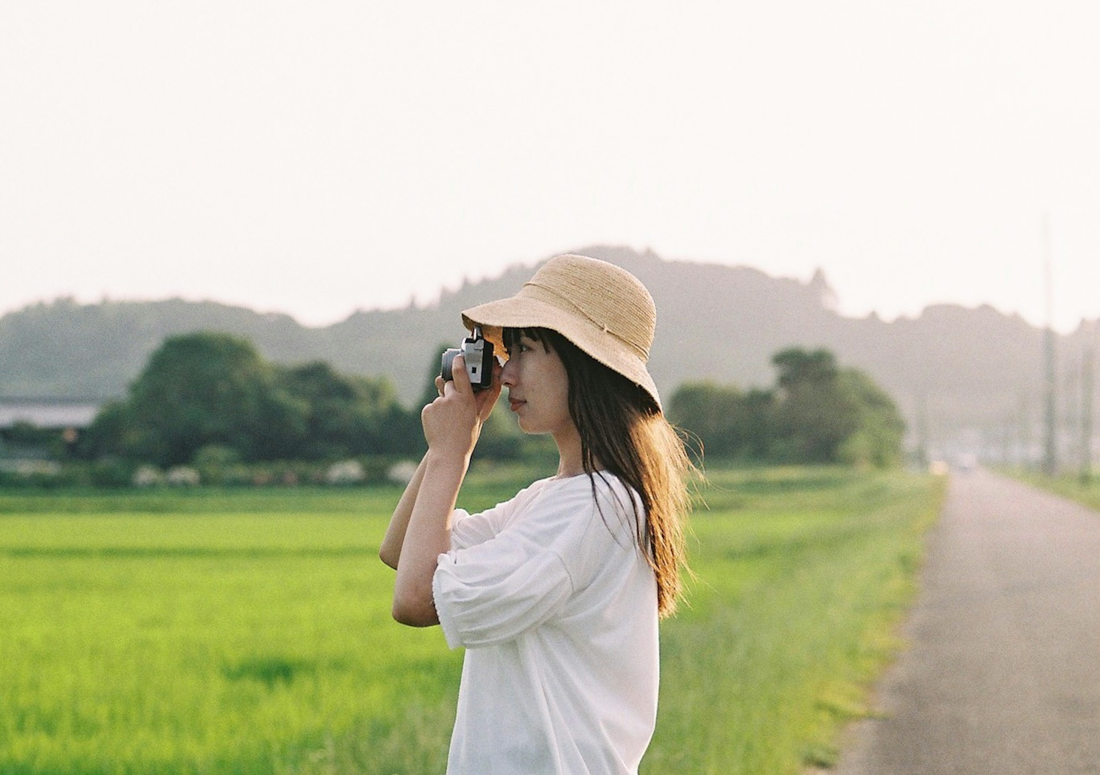 女性在鄉村風景中拿著相機