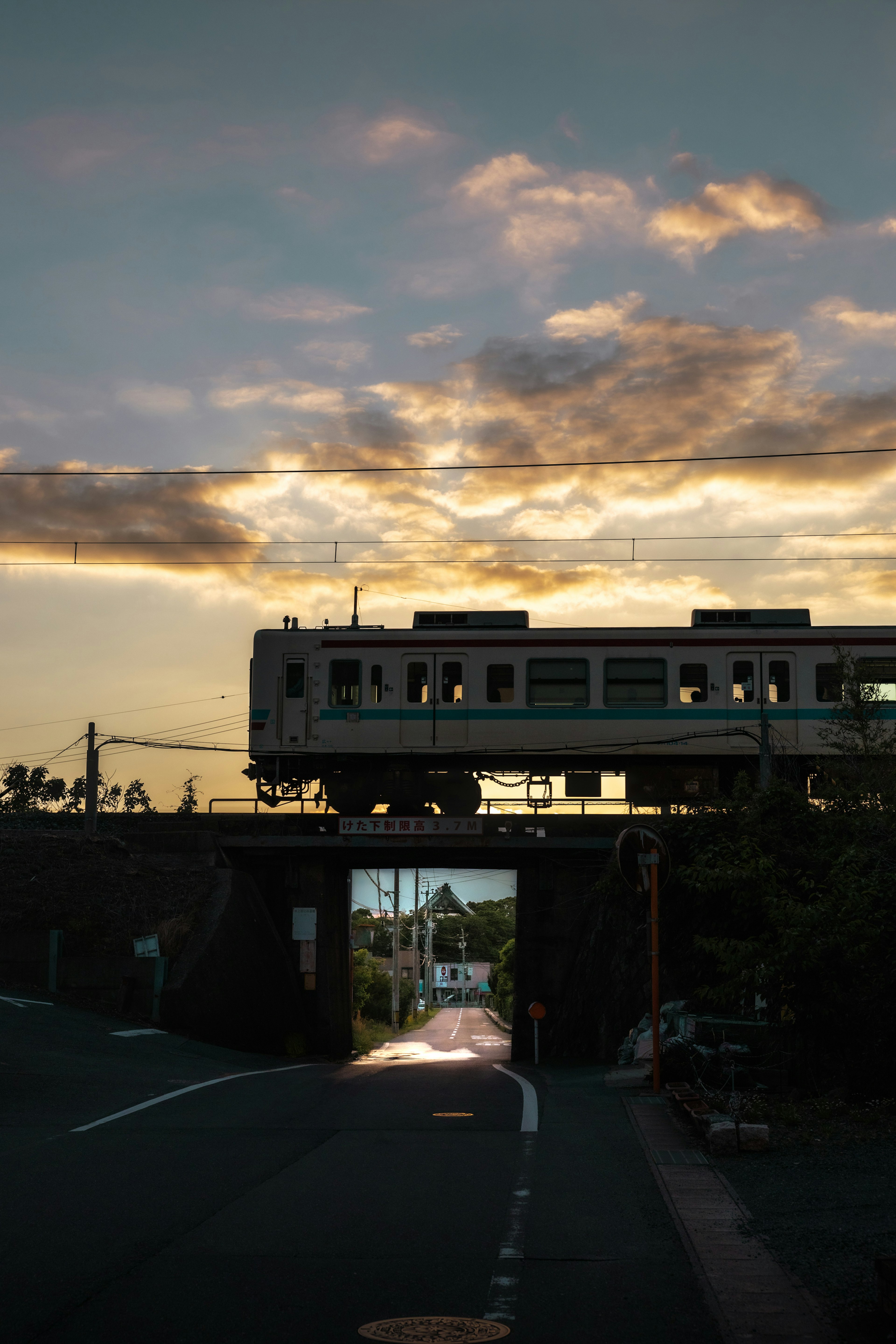 รถไฟที่ผ่านสะพานโดยมีท้องฟ้าในยามพระอาทิตย์ตกเป็นพื้นหลัง