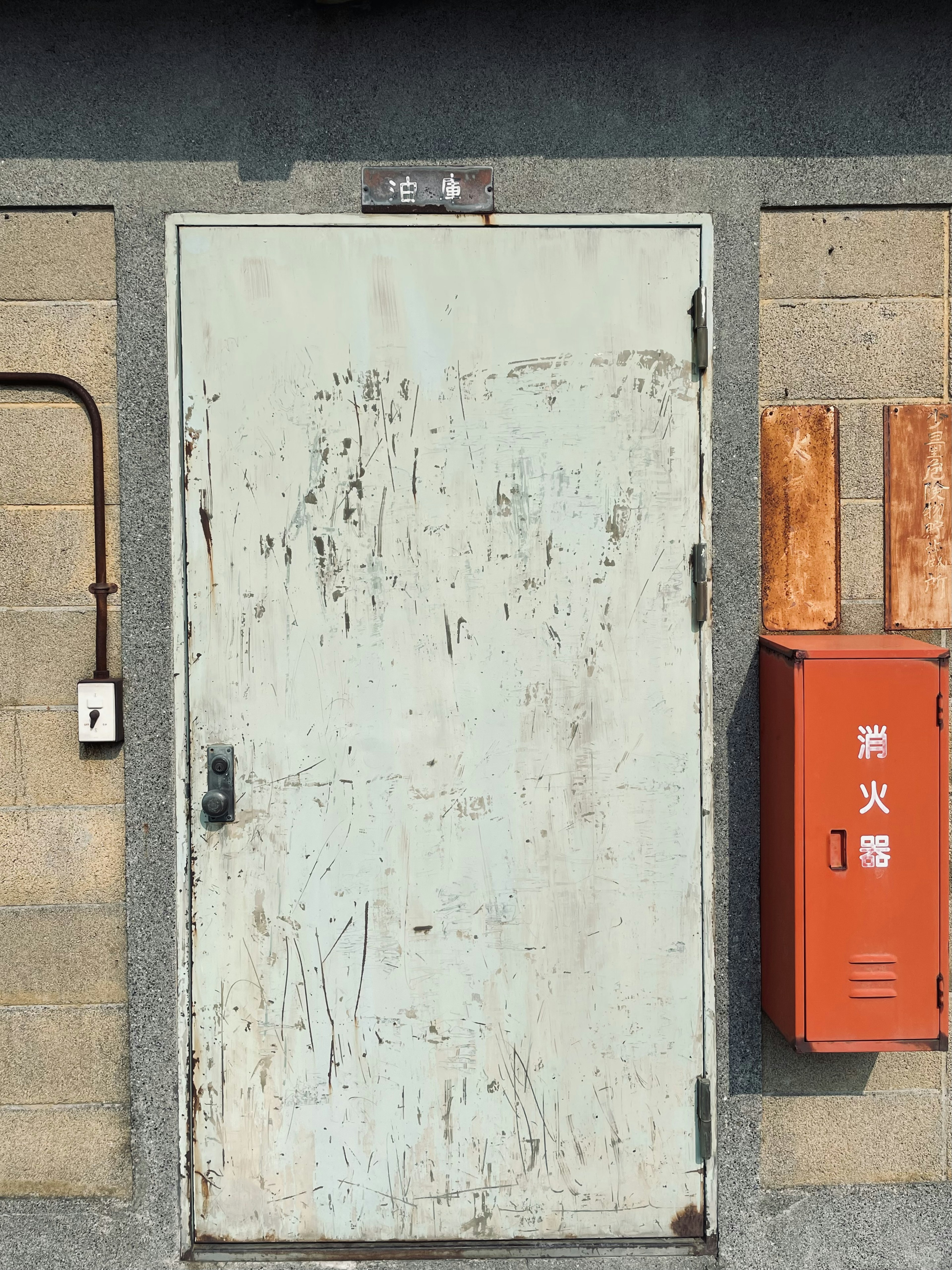 Porte verte ancienne avec une boîte aux lettres rouge sur le mur