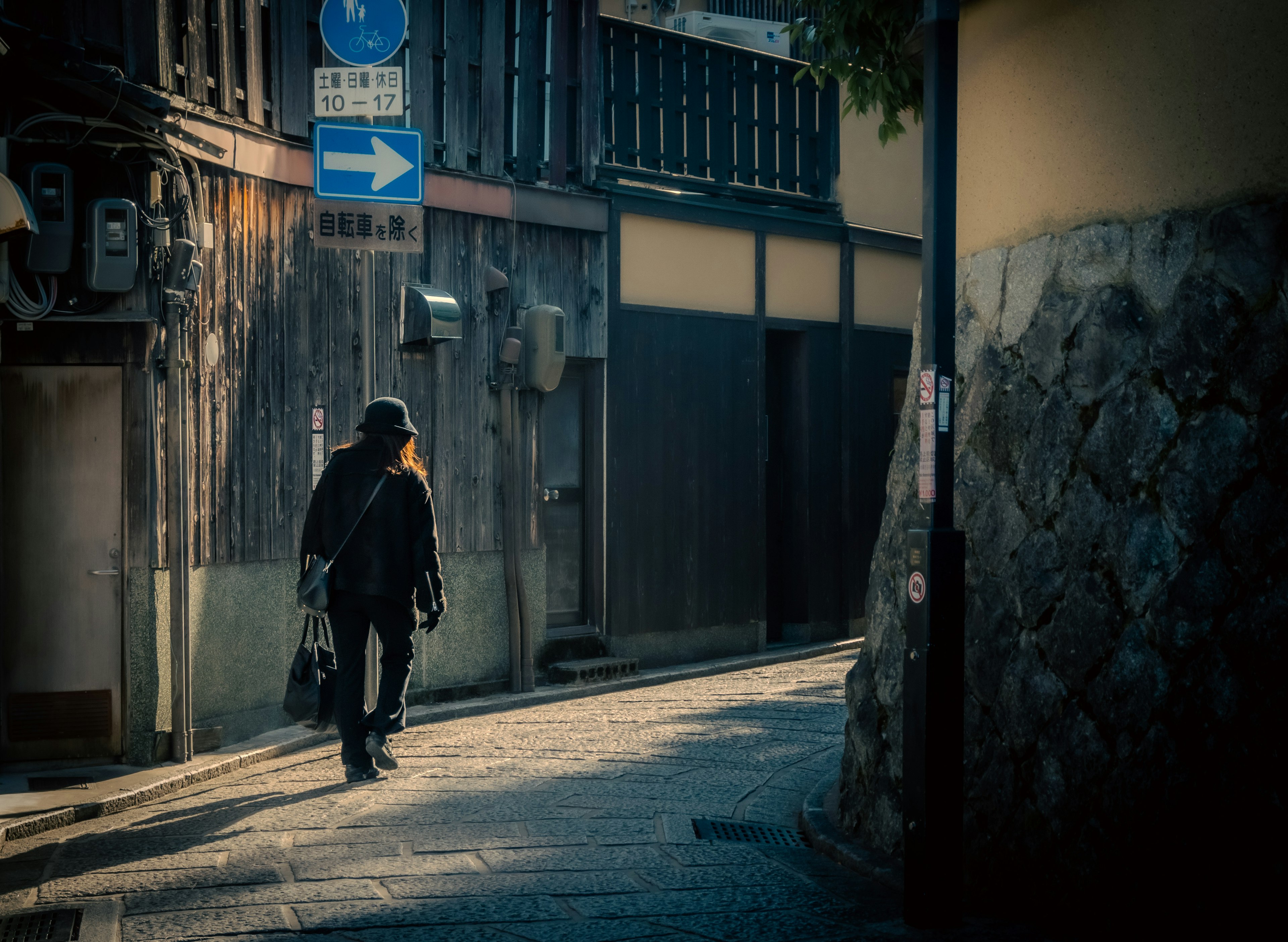 Una mujer caminando por una calle estrecha en un entorno urbano tranquilo