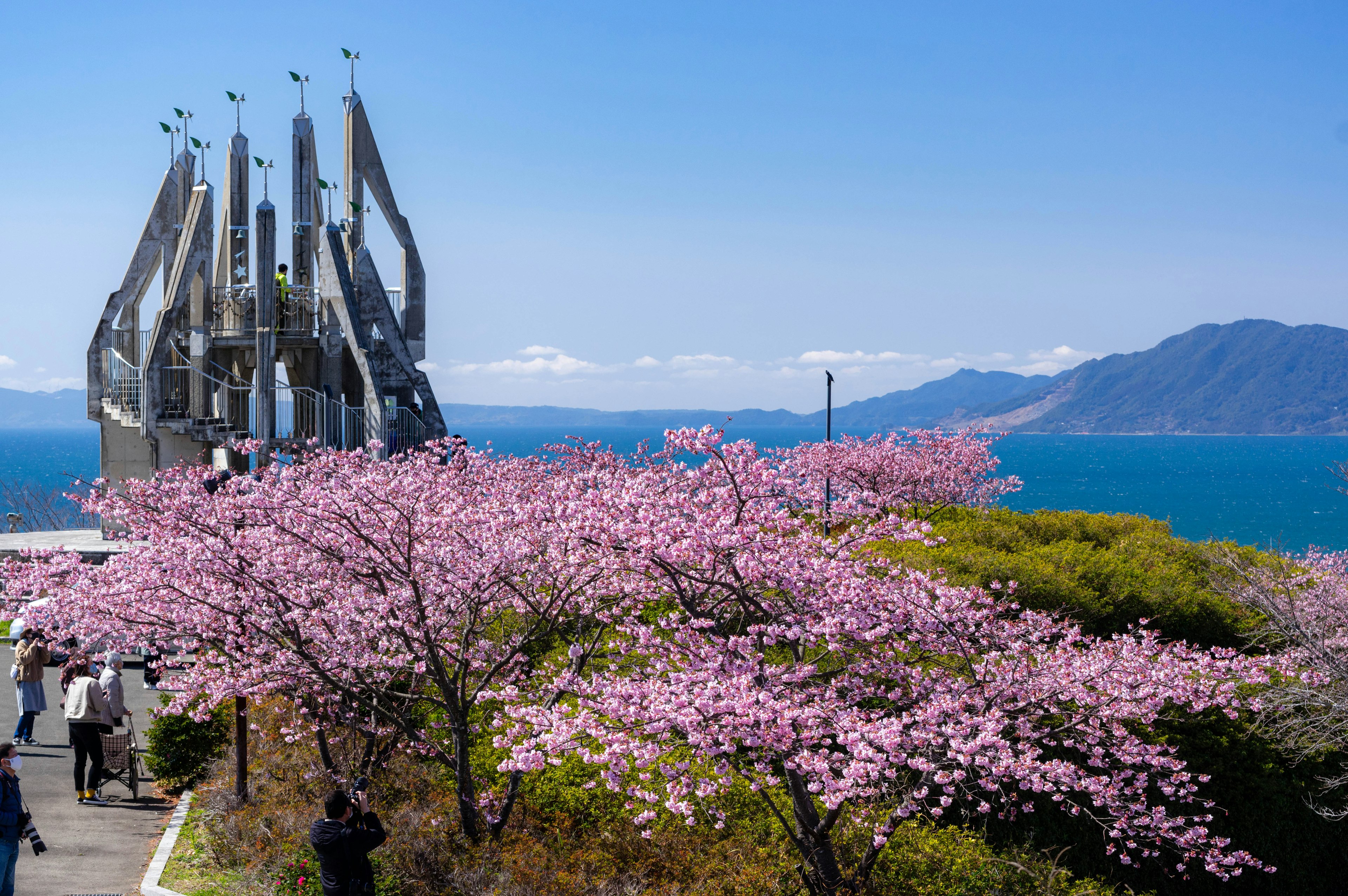 Vista escénica de cerezos en flor con una escultura moderna