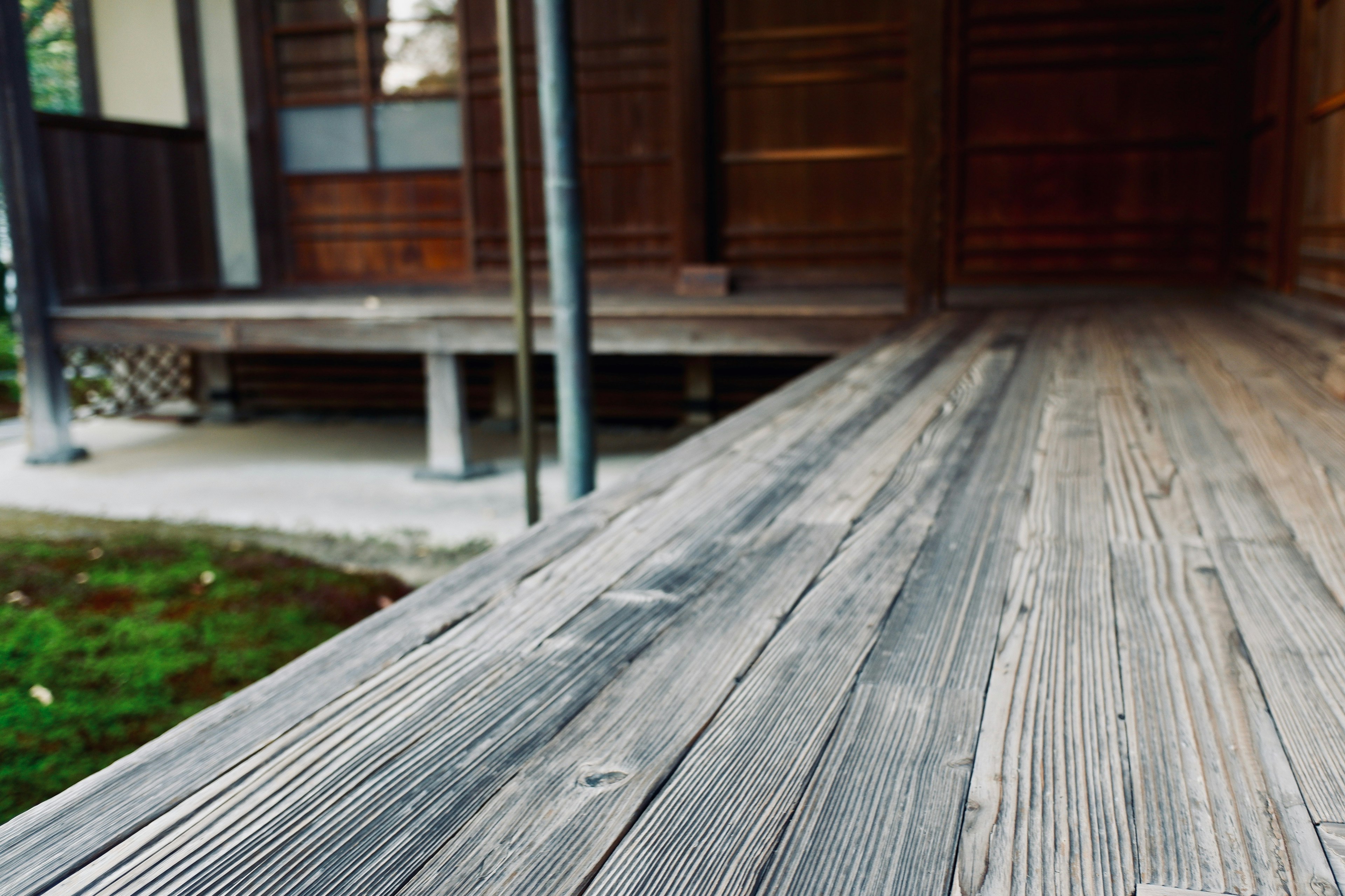 Bild, das eine Holzterrasse und die Fassade eines traditionellen japanischen Hauses zeigt